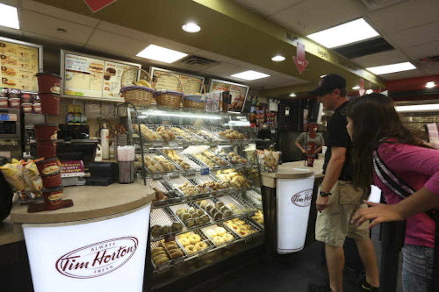 Customers at a Tim Hortons store in New York, Aug. 25, 2014. Burger King is in advanced talks to acquire Tim Hortons, the Canadian coffee-and-doughnut chain, for more than $8 billion, in what would be the largest ever acquisition of a restaurant chain. (Hiroko Masuike/The New York Times) ORG XMIT: MIN2014082519400680