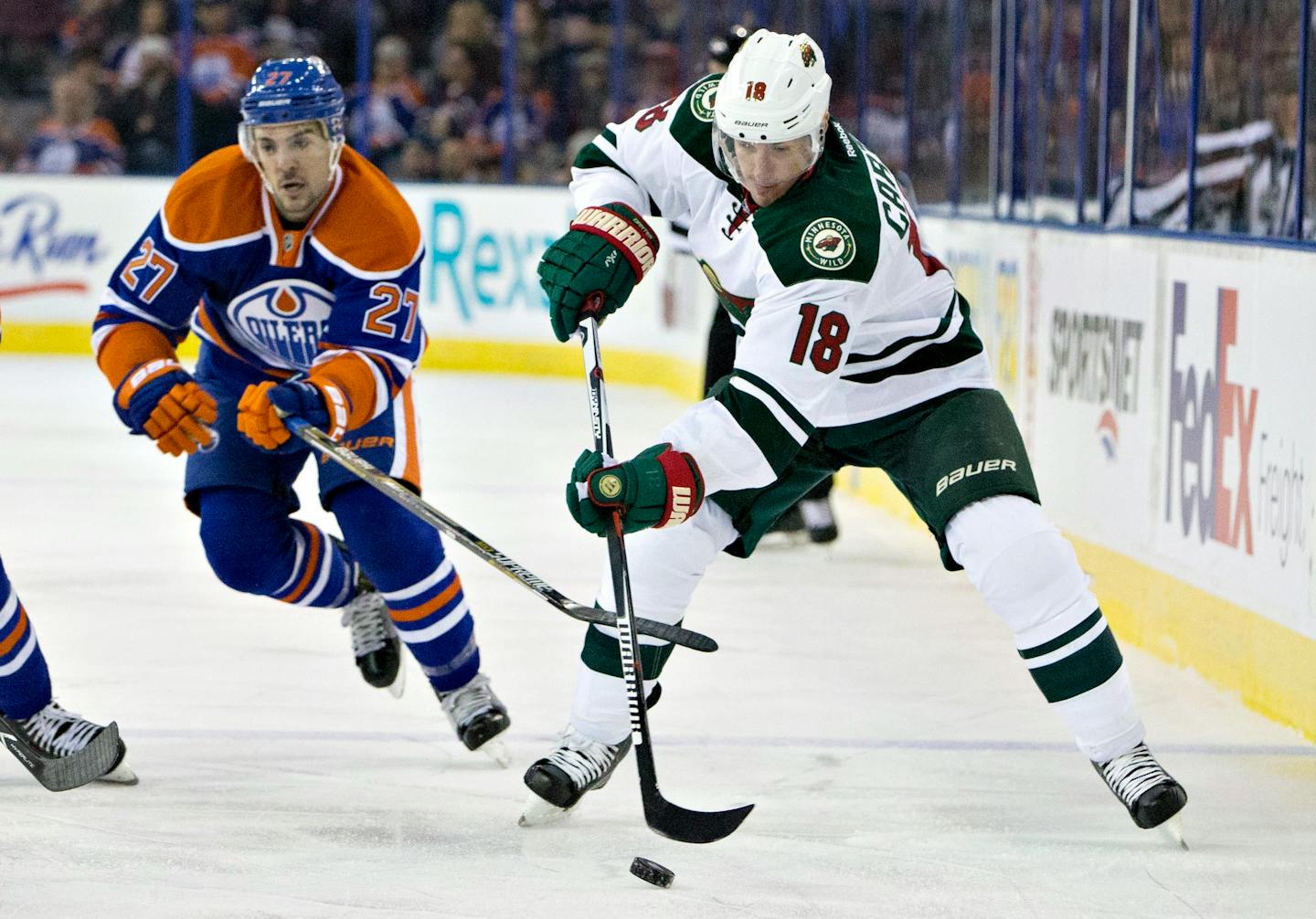 Minnesota Wild's Ryan Carter (18) is chased by Edmonton Oilers' Adam Clendening (27) during the first period of an NHL hockey game Thursday, Feb. 18, 2016, in Edmonton, Alberta. (Jason Franson/The Canadian Press via AP)