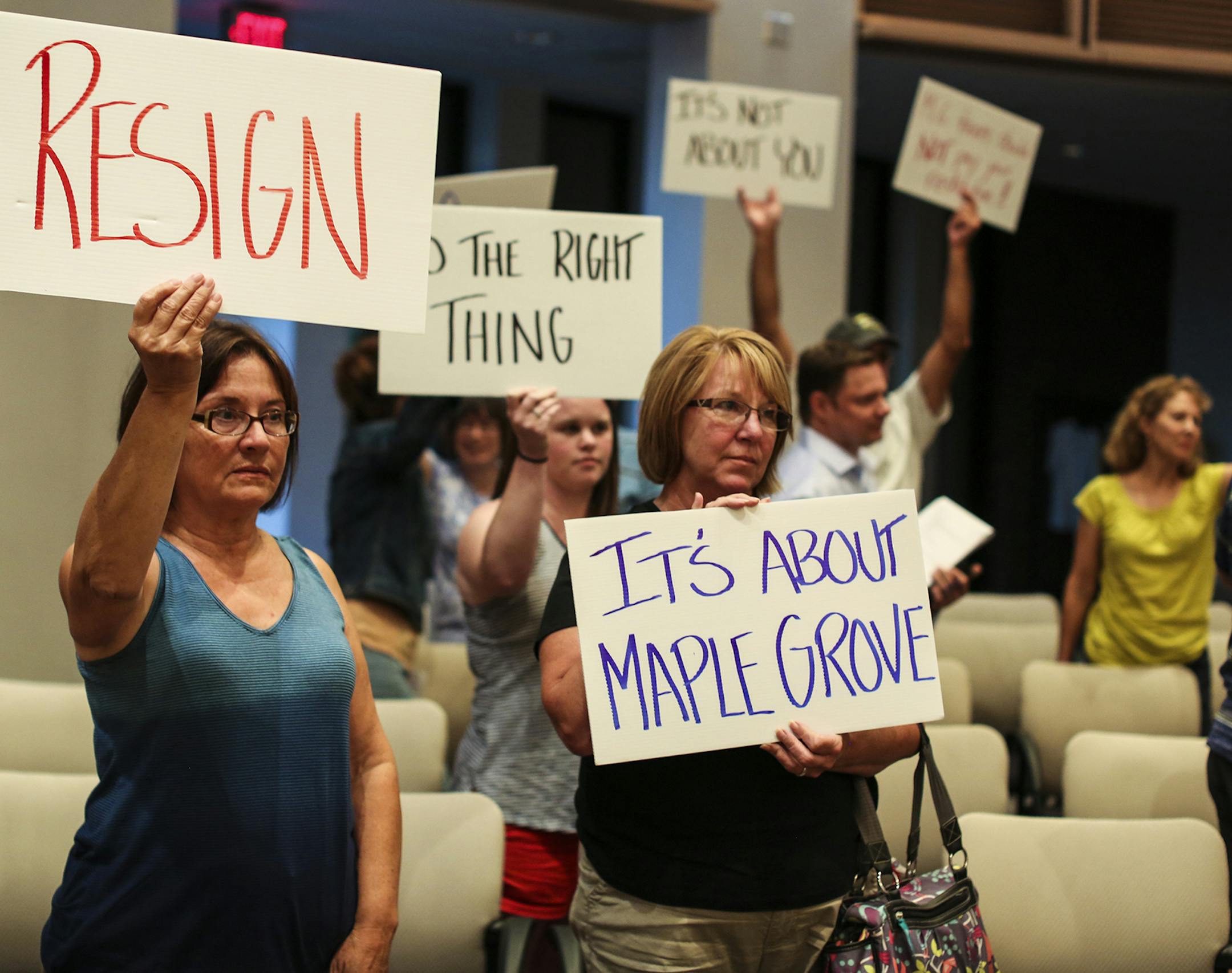 About two dozen protesters, asking for Council Member LeAnn Sargent to resign, including left to right front, Linda Schon and Nancy Whitecotton. held signs at the end of the city council meeting on Monday, August 4, 2014, in Maple Grove, Minn. Around two dozen residents were at Monday's Maple Grove City Council meeting to protest council member LeAnn Sargent's return to the council. Despite being convicted of and serving time for financially exploiting her dying father, Sargent says she's determ
