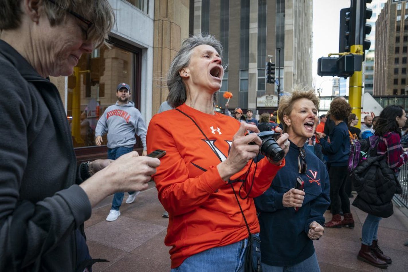 University of Virginia alumni Peggy Meehan, from left, Jennifer DiLalla and Lisa Stanfield cheer for their basketball team as they board their bus outside of the Marquette Hotel. The ladies were roommates at UVA in 1984, the last time their team made an appearance in the Final Four.