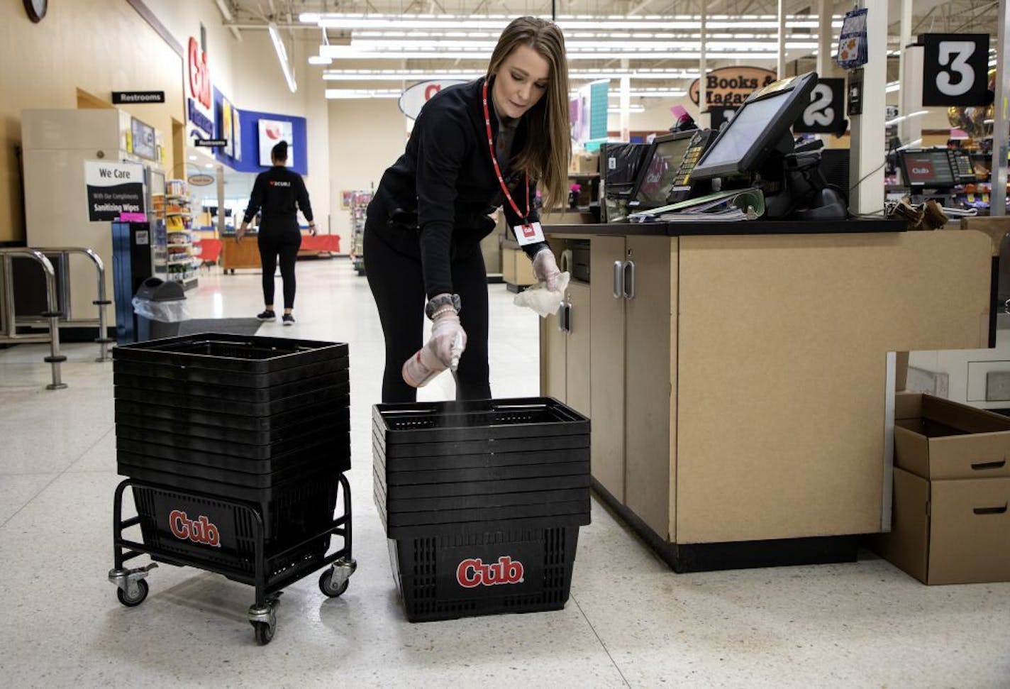 Danielle Hoppe, a customer service manager at a Cub Foods in Mankato, cleaned baskets between uses.