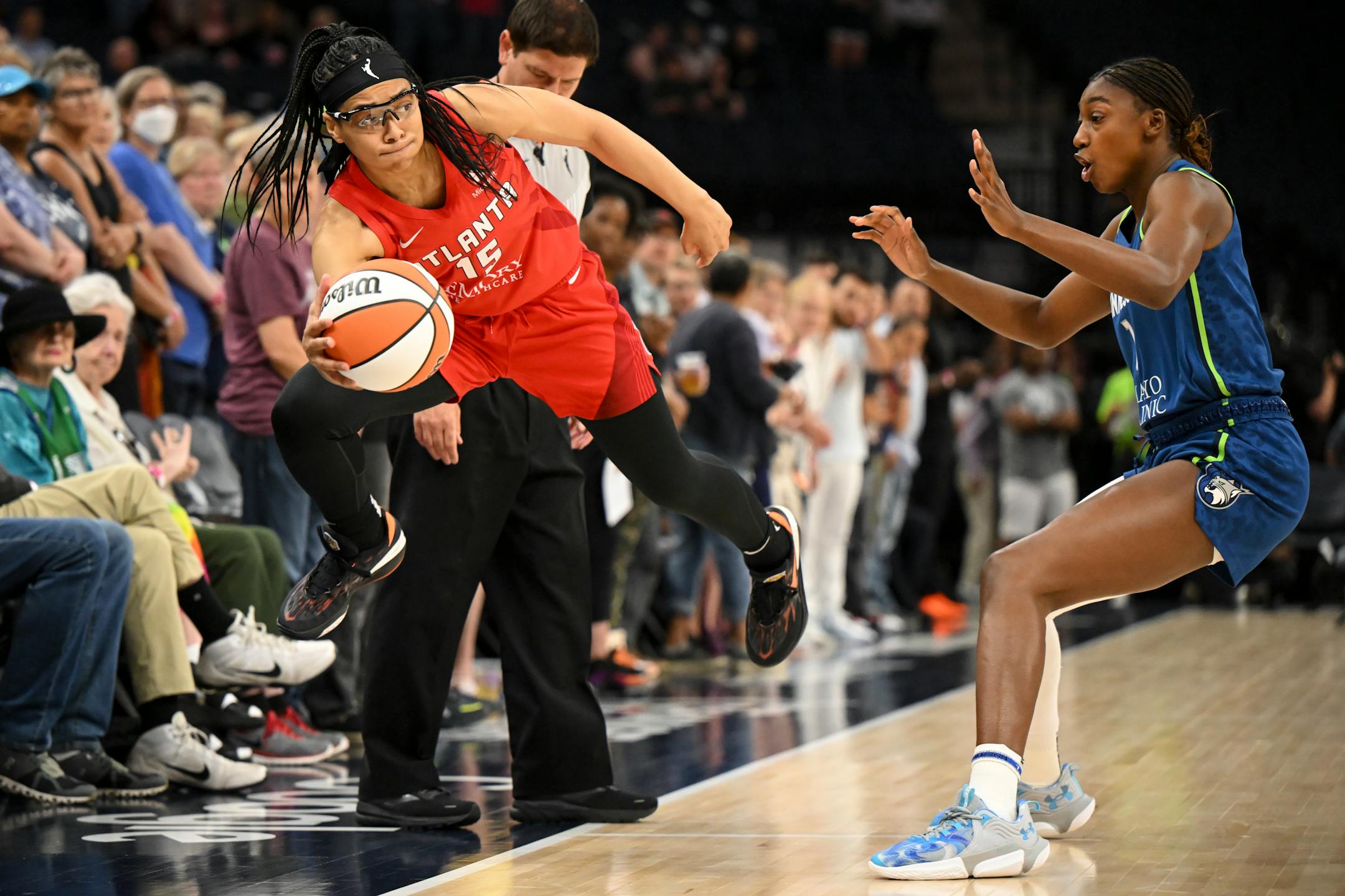 Atlanta Dream guard Allisha Gray leaps to keep the ball in bounds with Minnesota Lynx guard Diamond Miller in pursuit during the first quarter Tuesday, May 23, 2023, at Target Center in Minneapolis, Minn.