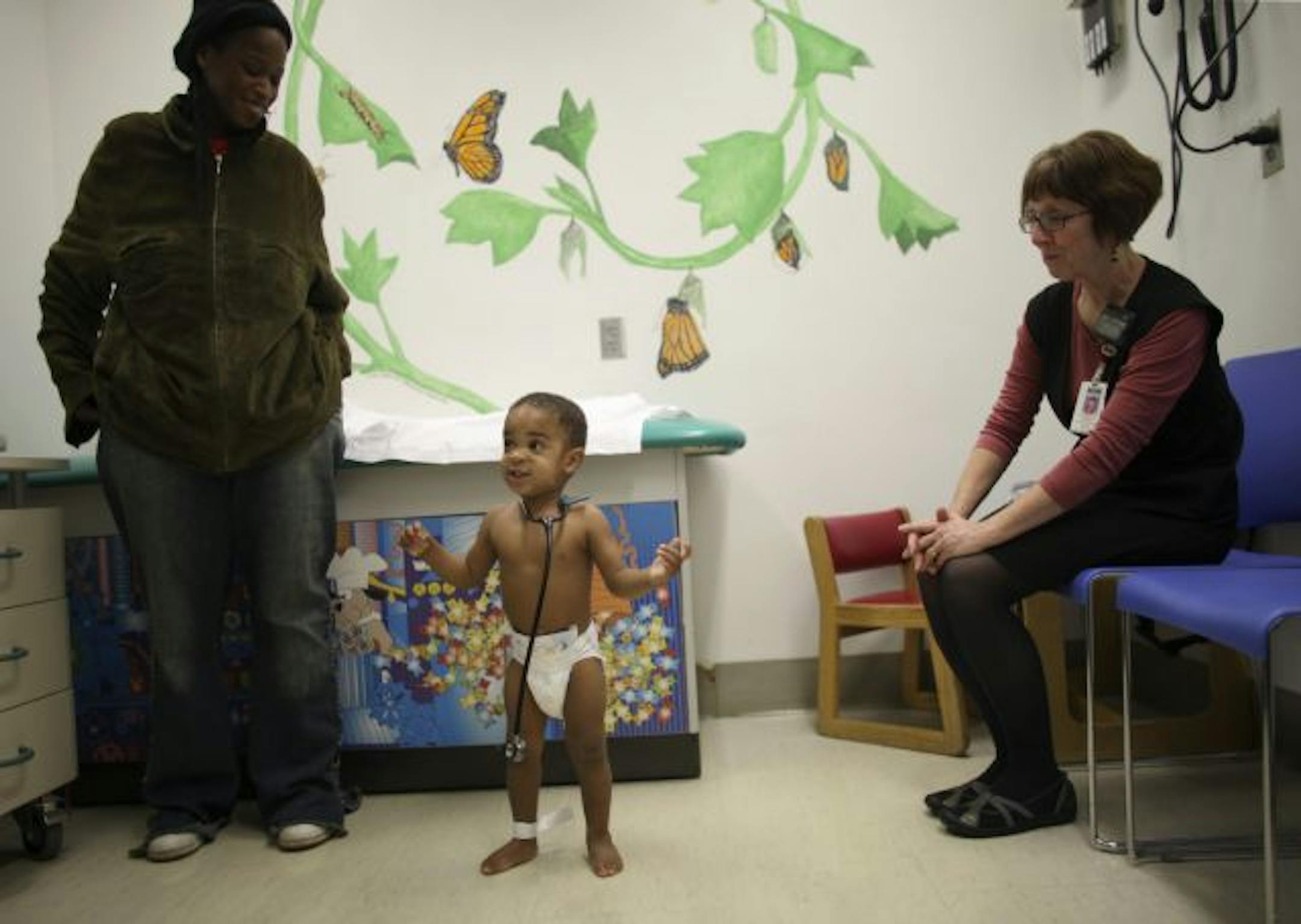 Toddler Brandon Hill, with his mother, Angela Coleman, and nurse practitioner Kathleen Nesset, got his 18-month checkup Tuesday at Hennepin County Medical Center. The center's new foundation has funded a public information campaign about the impact of state budget cuts on health care.