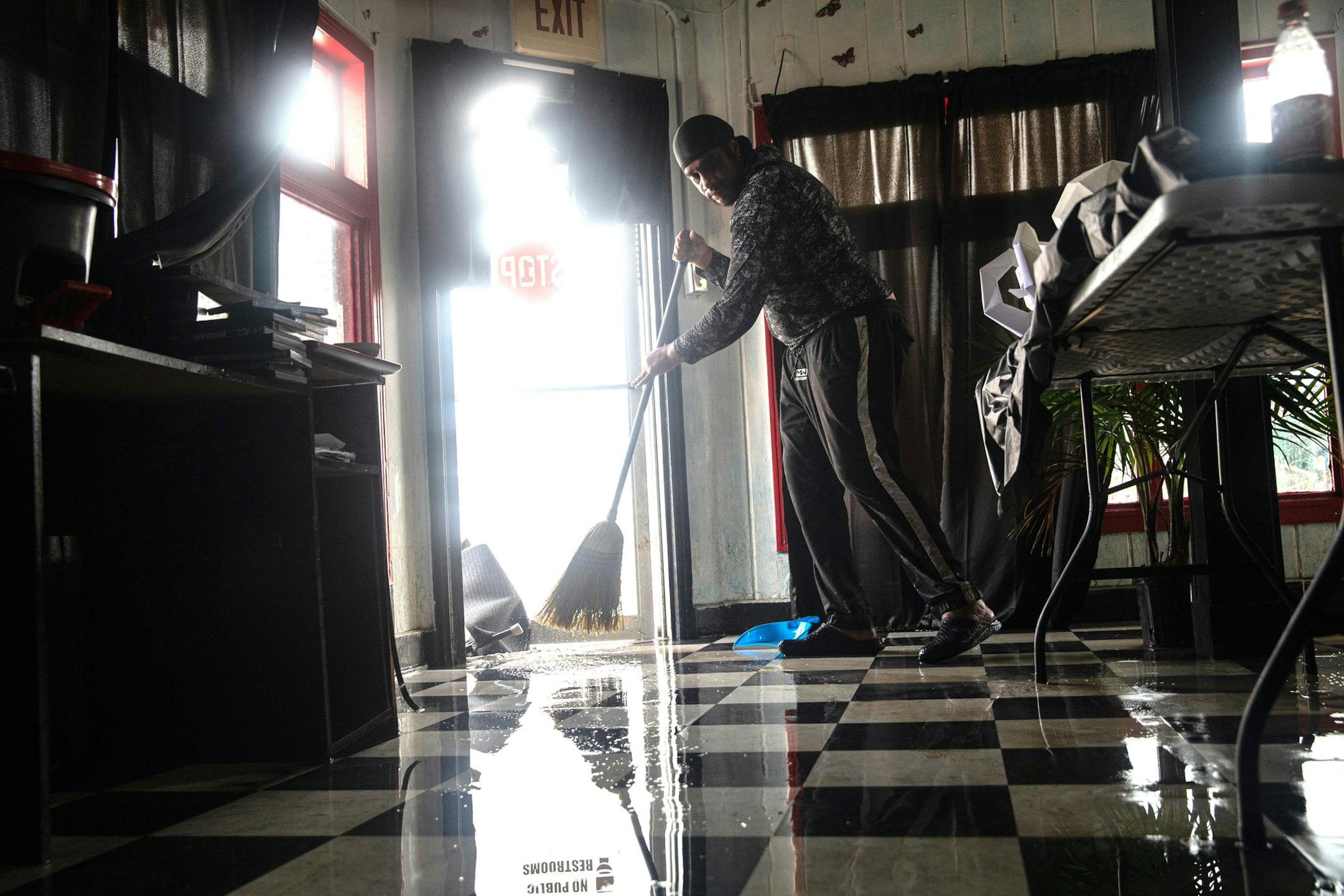 Clemente Runnels sweeps his shop, One Stop Shopping Center, after flooding from Hurricane Hanna in Corpus Christi, Texas, July 26, 2020. (Tamir Kalifa/The New York Times)