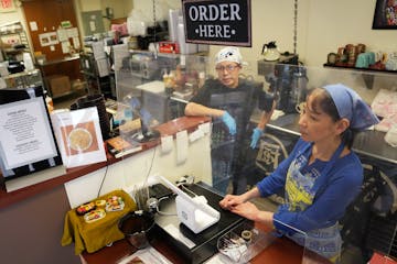 Junko Kumamoto, right, and her husband, Hiroshi, wait for customers during the start of the lunch rush at JK's Table, a Japanese restaurant they own t