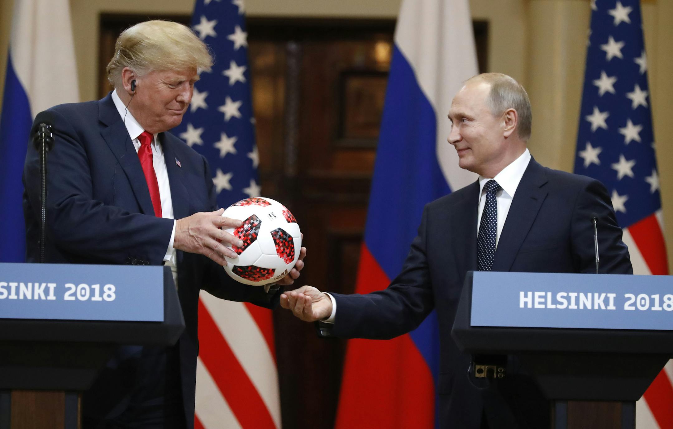 Russian President Vladimir Putin gives a soccer ball to U.S. President Donald Trump, left, during a press conference after their meeting at the Presidential Palace in Helsinki, Finland, Monday, July 16, 2018. (AP Photo/Alexander Zemlianichenko)