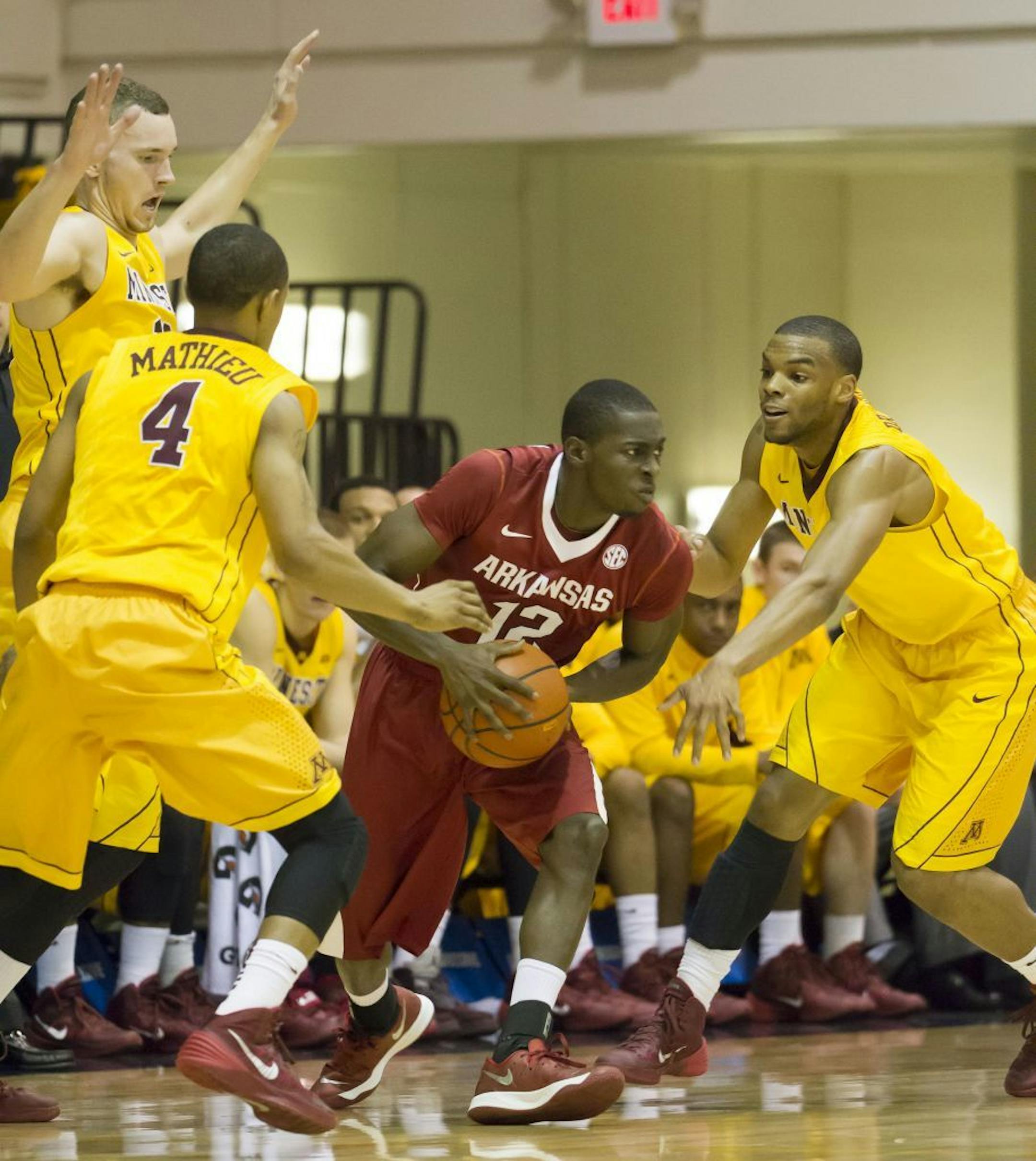 Minnesota forward Oto Osenieks, top left, along with his teammates guard Deandre Mathieu (4) and guard Andre Hollins attempt to trap Arkansas guard Fred Gulley III (12) in the first half of an NCAA college basketball game at the Maui Invitational on Tuesday, Nov. 26, 2013, in Lahaina, Hawaii.