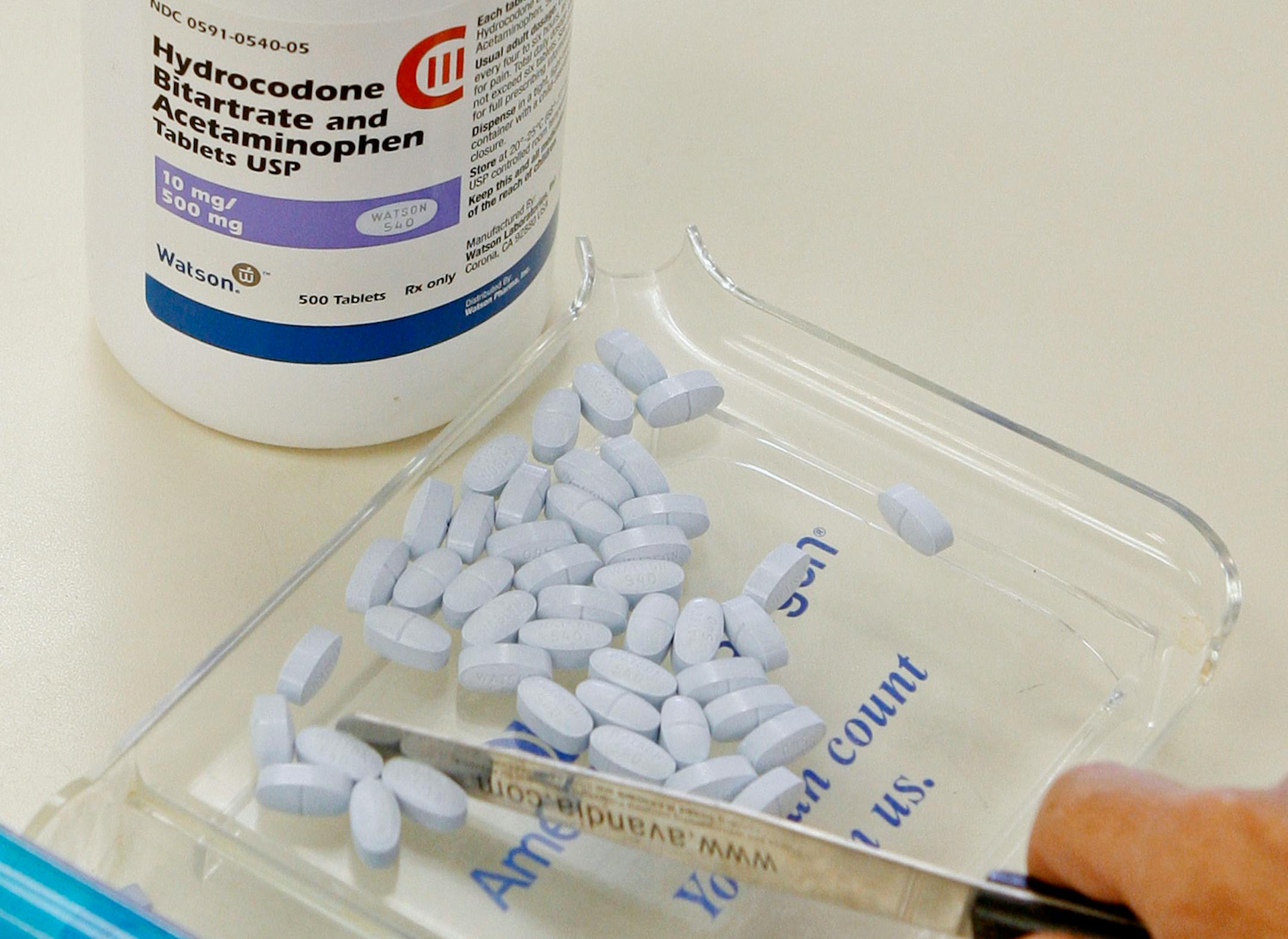 In this file photo, a pharmacy technician poses for a picture with hydrocodone and acetaminophen tablets, also known as Vicodin, at the Oklahoma Hospital Discount Pharmacy in Edmond, Okla. Opioids including Vicodin and fentanyl patches worked no better than Tylenol and other over-the-counter pills at relieving chronic back pain and hip and knee arthritis in a year-long study of mostly men at Minneapolis VA clinics.