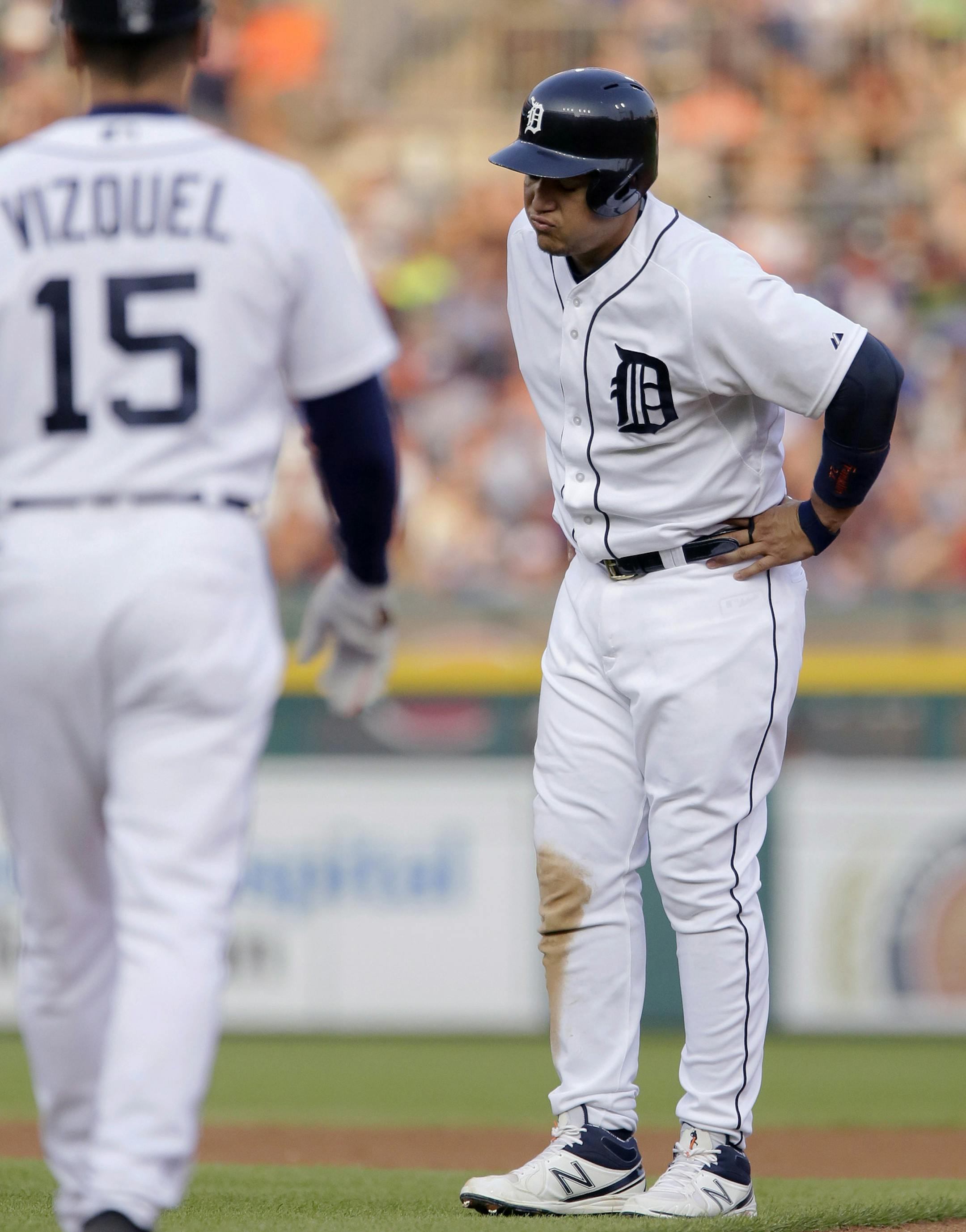 Detroit Tigers' Miguel Cabrera is approached by first base coach Omar Vizquel after pulling up while running to second base during the fourth inning of a baseball game against the Toronto Blue Jays on Friday, July 3, 2015, in Detroit. Cabrera left the game with a left calf strain and will undergo an MRI. (AP Photo/Duane Burleson)