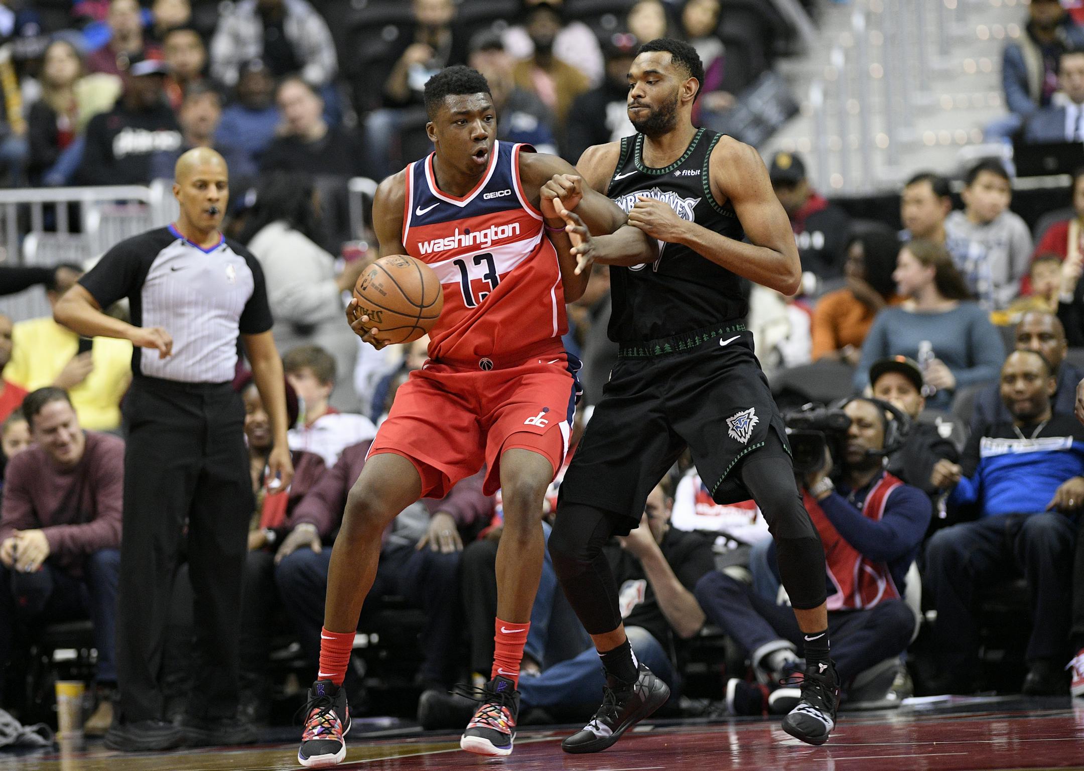 Washington Wizards center Thomas Bryant (13) dribbles the ball against Minnesota Timberwolves forward Keita Bates-Diop, right, during the first half of an NBA basketball game, Sunday, March 3, 2019, in Washington. (AP Photo/Nick Wass) ORG XMIT: VZN10