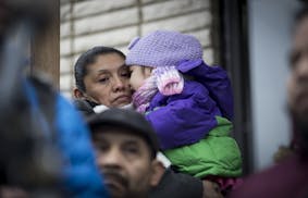 Marta Pacheco held her daughter Heidi as she joined about a dozen people protesting rising rents at a series of buildings along Pleasant and Pillsbury
