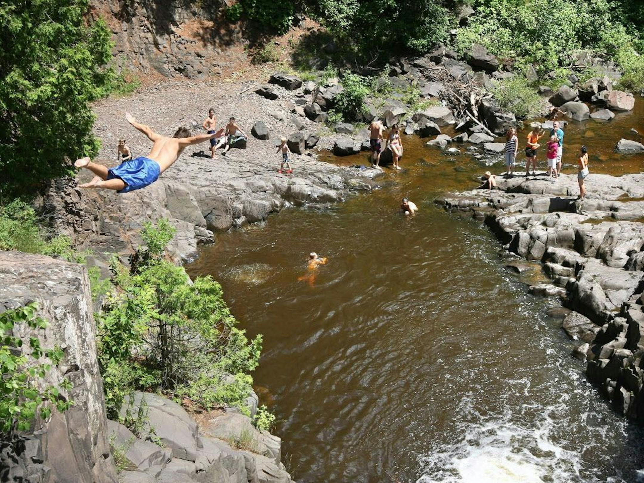In this July 6, 2010, photo, Eric Van Puymbrouck, 17, of Superior, Wis,.dives into "the Deeps" on Amity Creek from a modest cliff face in Duluth. "I love the adrenaline," said Van Puymbrouck.