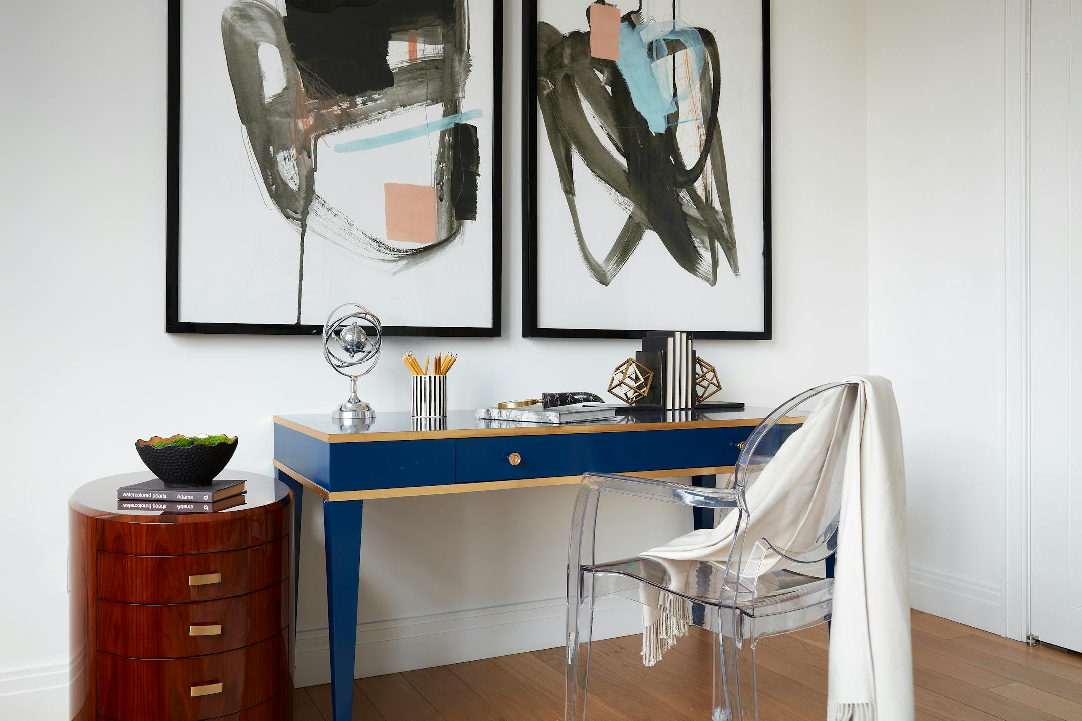 Soft muted pastel artwork is paired with an indigo lacquered desk to create a sense of glamour in this office space. (Scott Gabriel Morris/TNS)