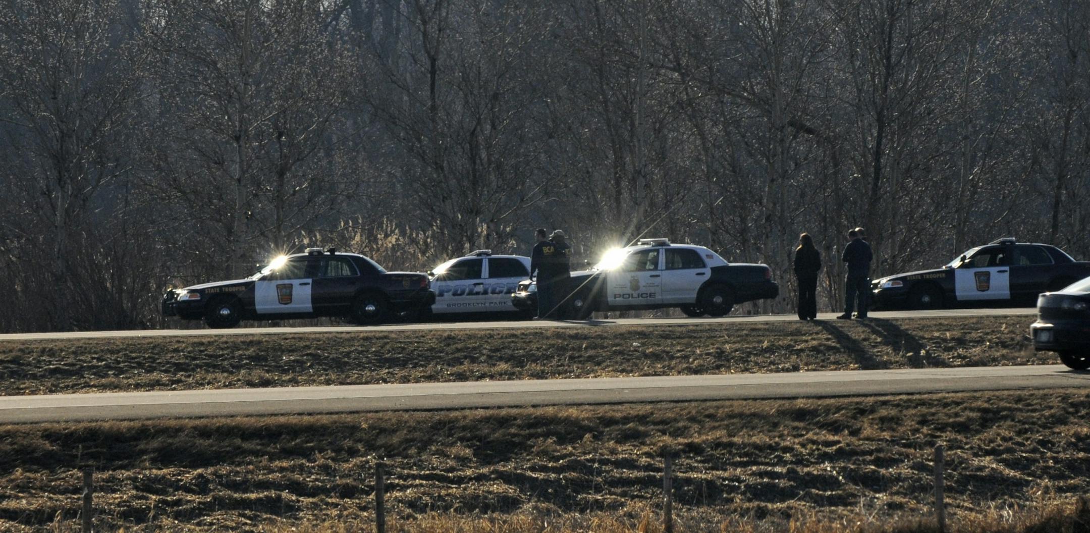 Law enforcement officials investigate the scene where a suspect was shot by authorities on Interstate Hwy. 35E near the junction with 35W.