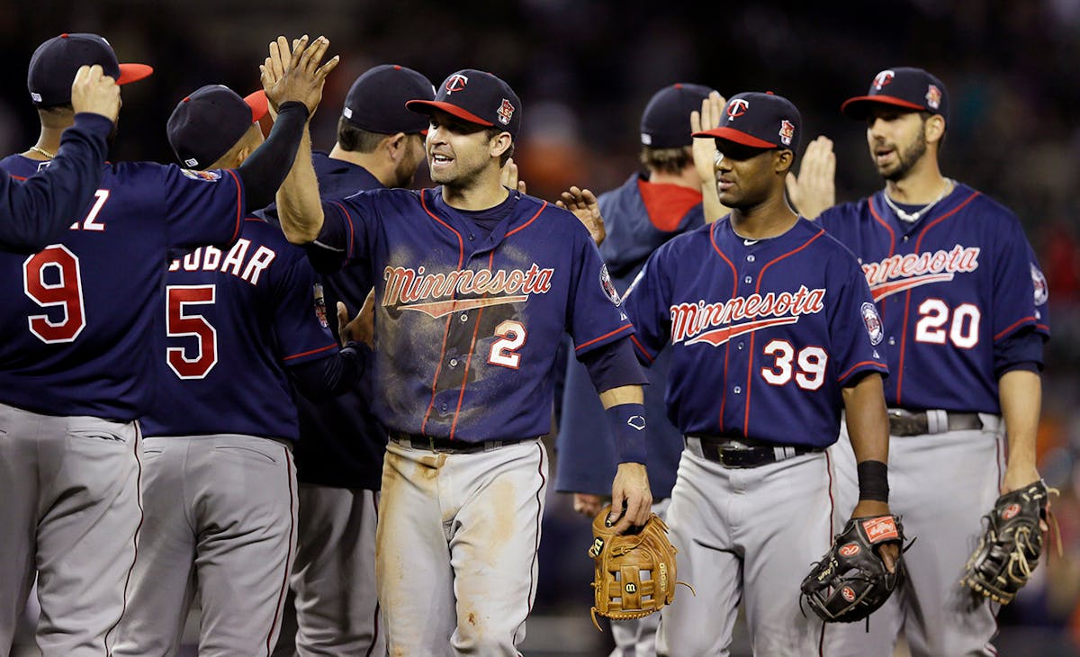 Minnesota Twins second baseman Brian Dozier (2), shortstop Danny Santana (39) and right fielder Chris Colabello (20) celebrate their 2-1 win over the 