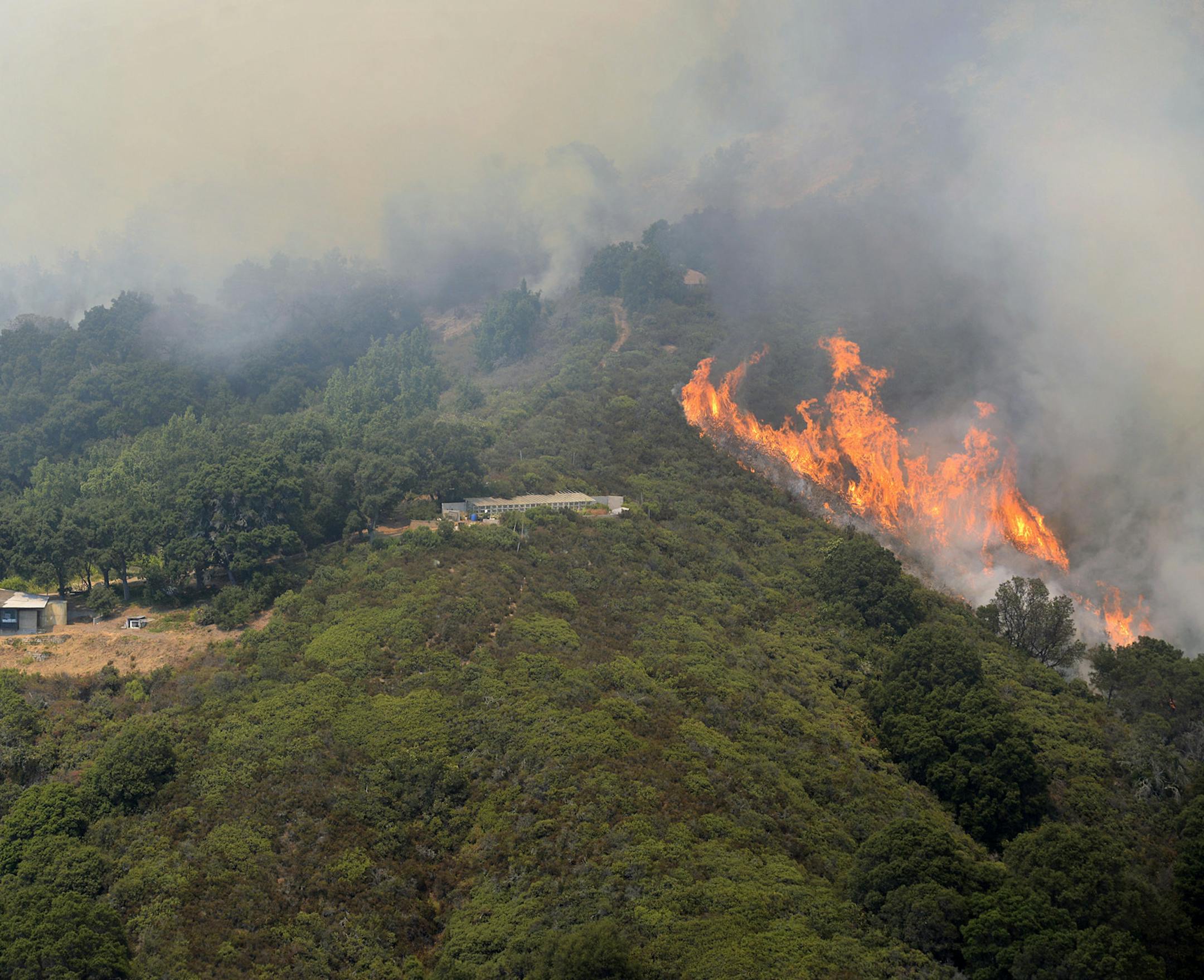 A wildfire burns in the Palo Colorado Canyon in the scenic Big Sur region of California's Central Coast, Monday, July 25, 2016. Fire crews have made some gains against a massive wildfire burning in rugged terrain near the scenic Big Sur region. (David Royal/The Monterey County Herald via AP) MANDATORY CREDIT