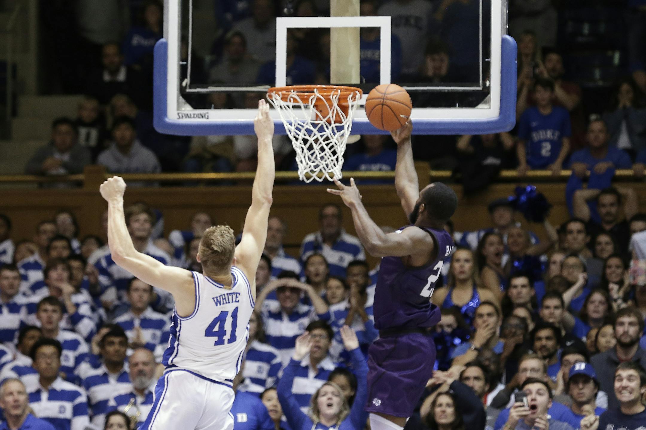 FILE - Stephen F. Austin forward Nathan Bain (23) drives for the game-winning basket against Duke forward Jack White (41) during overtime in an NCAA college basketball game in Durham, N.C., in this Tuesday, Nov. 26, 2019, file photo. Bain provided one of college basketball's signature moments last season, a buzzer-beating layup in overtime to give unheralded Stephen F. Austin a stunning upset over Duke. But that became just a sliver of the story that night. His layup won a game -- and rebuilt a