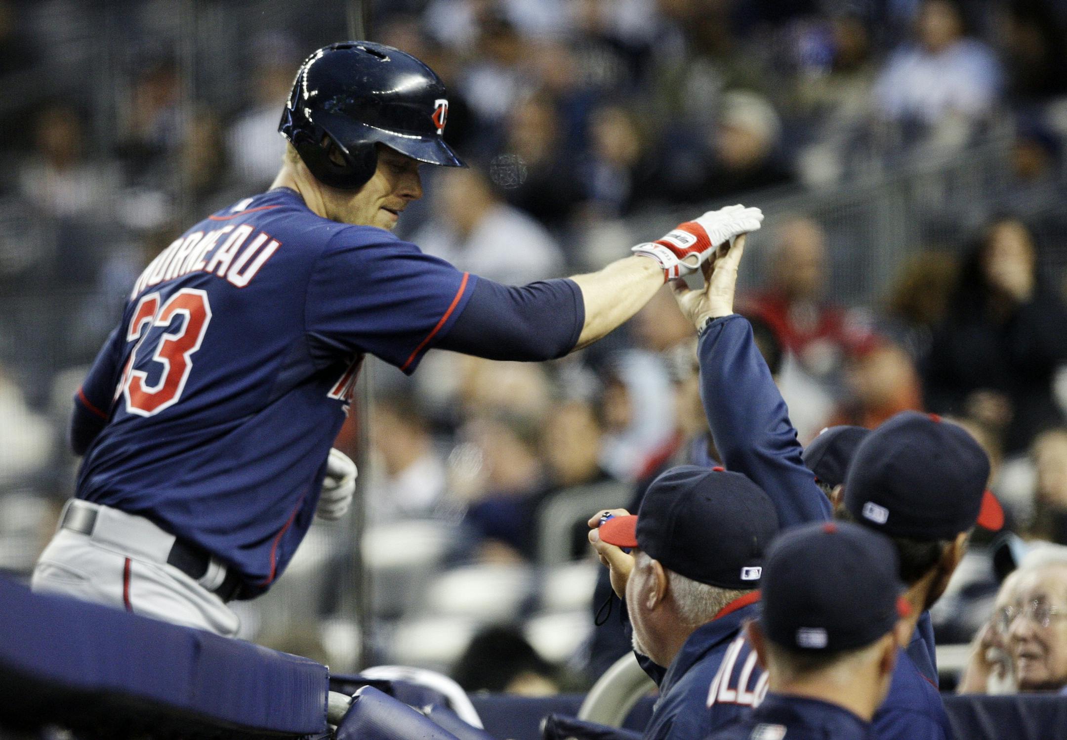 Minnesota Twins' Justin Morneau (33) celebrates with teammates after hitting a two-run home run against the New York Yankees at Yankee Stadium in New York, Wednesday, April 18, 2012.
