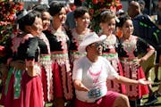 Tou Ger Xiong posed with a group of dancers at Hmong Minnesota Day, which he helped found, at the Minnesota State Fair in 2021.