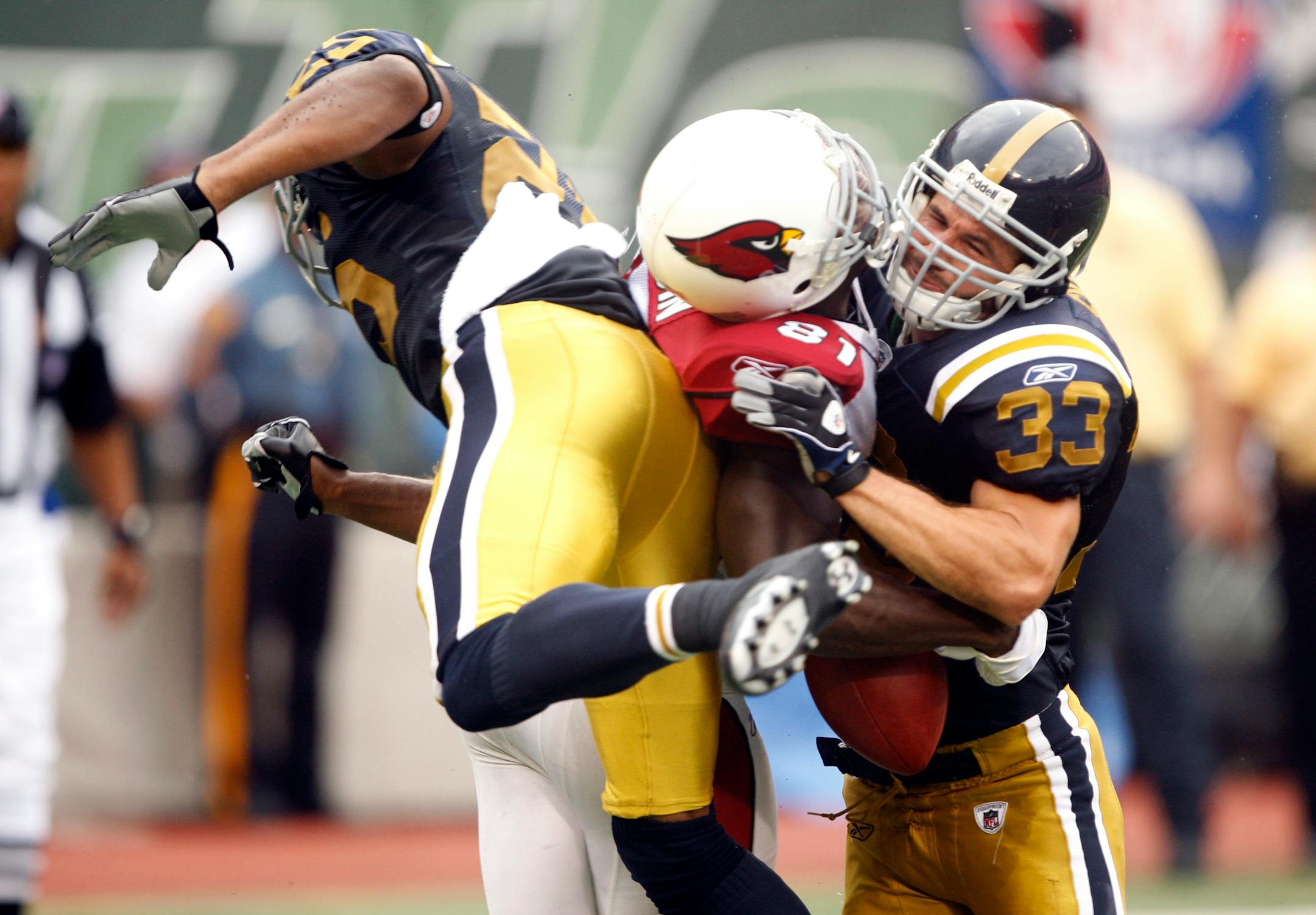 Jets defenders Kerry Rhodes (left) and Eric Smith sandwiched Cardinals receiver Anquan Boldin earlier this season. Some players are lamenting the NFL's crackdown on violent hits this season.