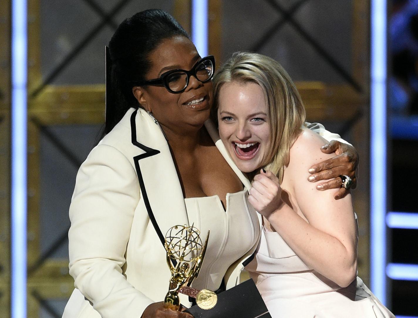 Oprah Winfrey, left, presents the award for outstanding drama series for "The Handmaid's Tale" to Elisabeth Moss at the 69th Primetime Emmy Awards on Sunday, Sept. 17, 2017, at the Microsoft Theater in Los Angeles. (Photo by Chris Pizzello/Invision/AP) ORG XMIT: CACV417