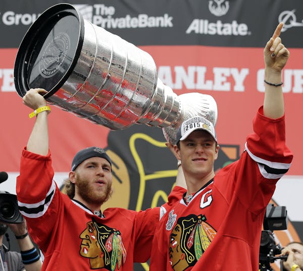 Chicago Blackhawks right wing Patrick Kane, left, and center Jonathan Toews celebrate as they hold up the Stanley Cup Trophy during a rally at Soldier