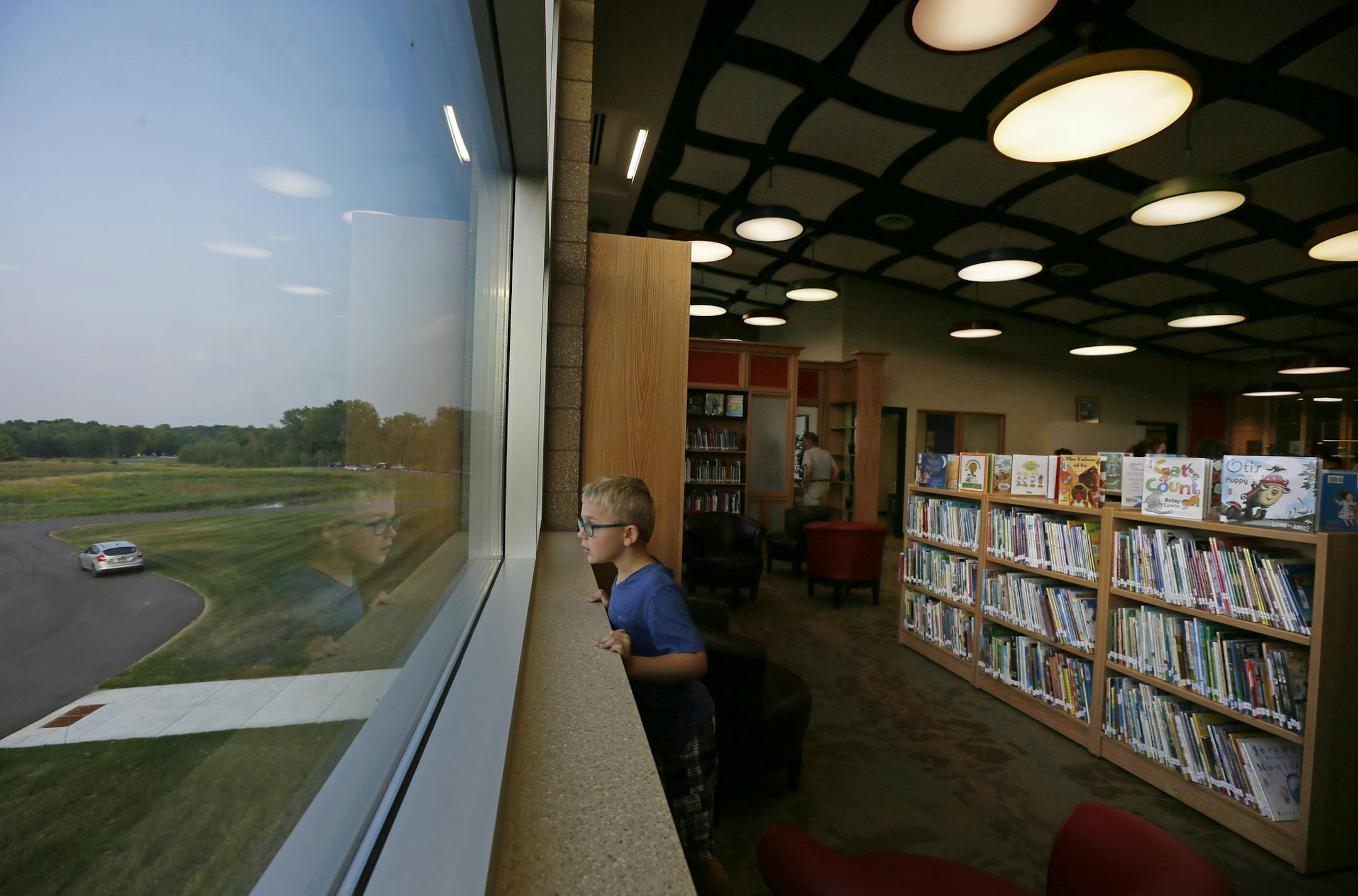 Evan Heinsch 7, a second grader checked out the view from the window of the media center during a community celebration of the new Wildwood new k-2 elementary school Tuesday Aug 19 ,2013 in Grant , MN. ] JERRY HOLT ‚Ä¢ jerry.holt@startribune.com