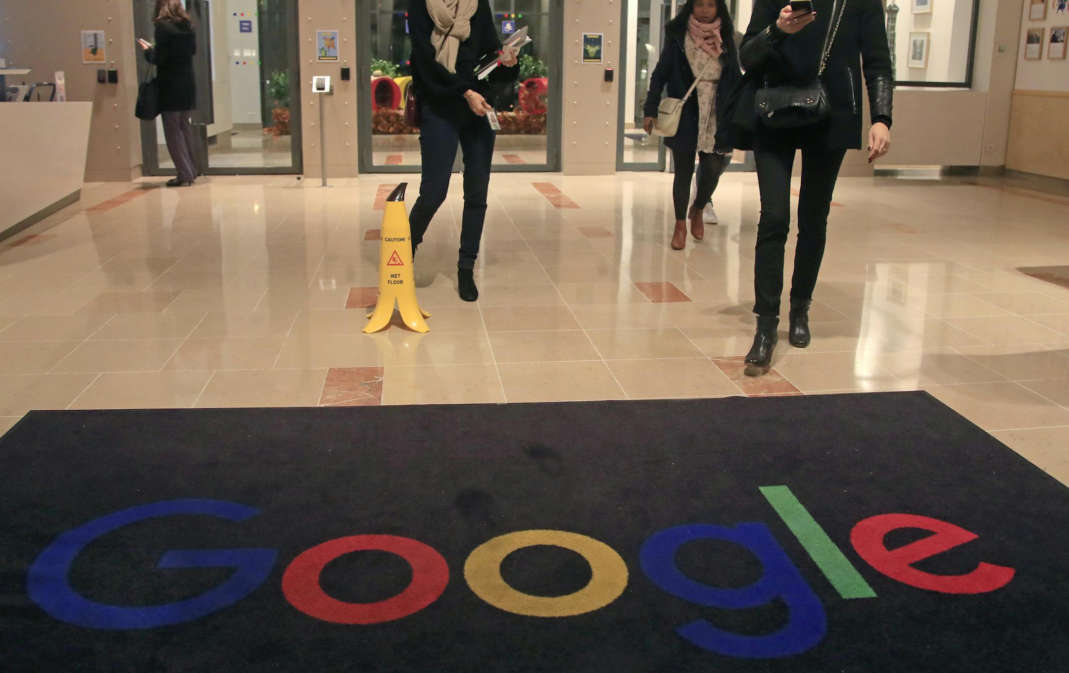 File - In this Nov.18, 2019 file photo, Google employees walks out of the entrance hall of Google France in Paris. France is bristling at a U.S. threat to slap 100% tariffs on French cheeses, Champagne and other products, with the French leader telling President Donald Trump on Tuesday that the move would amount to an attack on all of Europe.The U.S. Trade Representative proposed the tariffs on $2.4 billion in goods Monday in retaliation for a French tax on global tech giants including Google, A