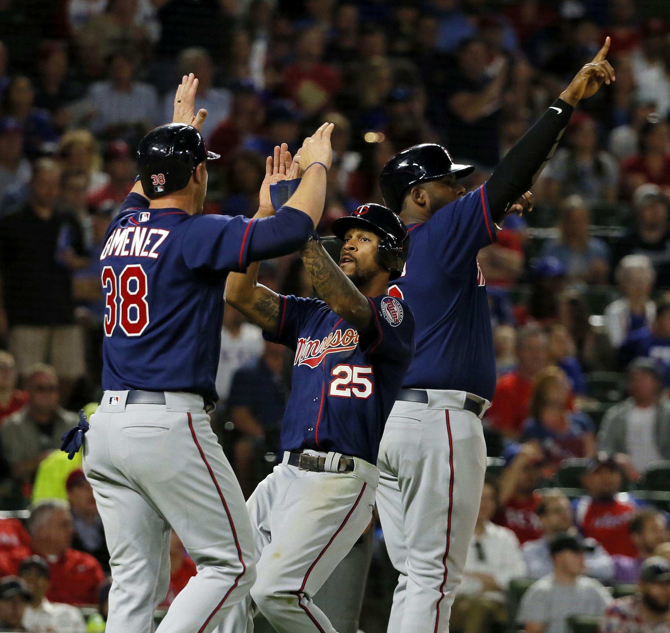 Minnesota Twins' Chris Gimenez (38), Byron Buxton (25) and Kennys Vargas, rear, celebrate scoring on a bases clearing double by Brian Dozier in the fifth inning of a baseball game against the Texas Rangers in Arlington, Texas, Monday April 24, 2017. Dozier's hit came off of Rangers starter Martin Perez. (AP Photo/Tony Gutierrez)