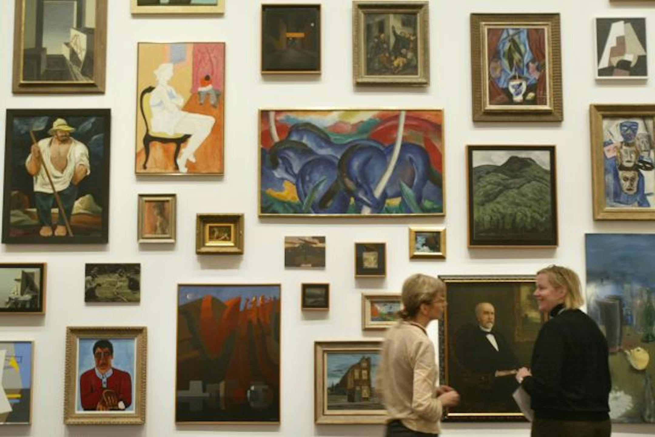 Curators Darsie Alexander, left, and Elizabeth Carpenter flanked a portrait of museum founder T.B. Walker in a new installation of Walker Art Center's collection.