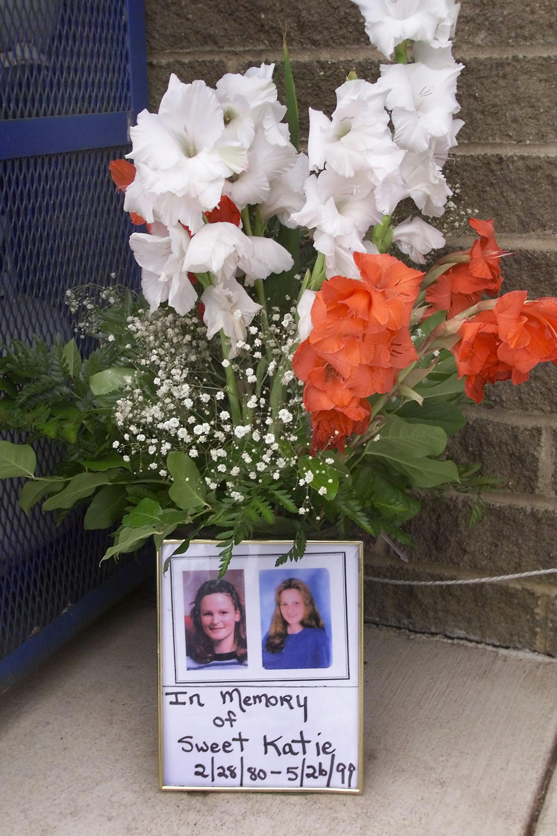 A sign and flowers at the gas station where Katie Poirier was kidnapped.