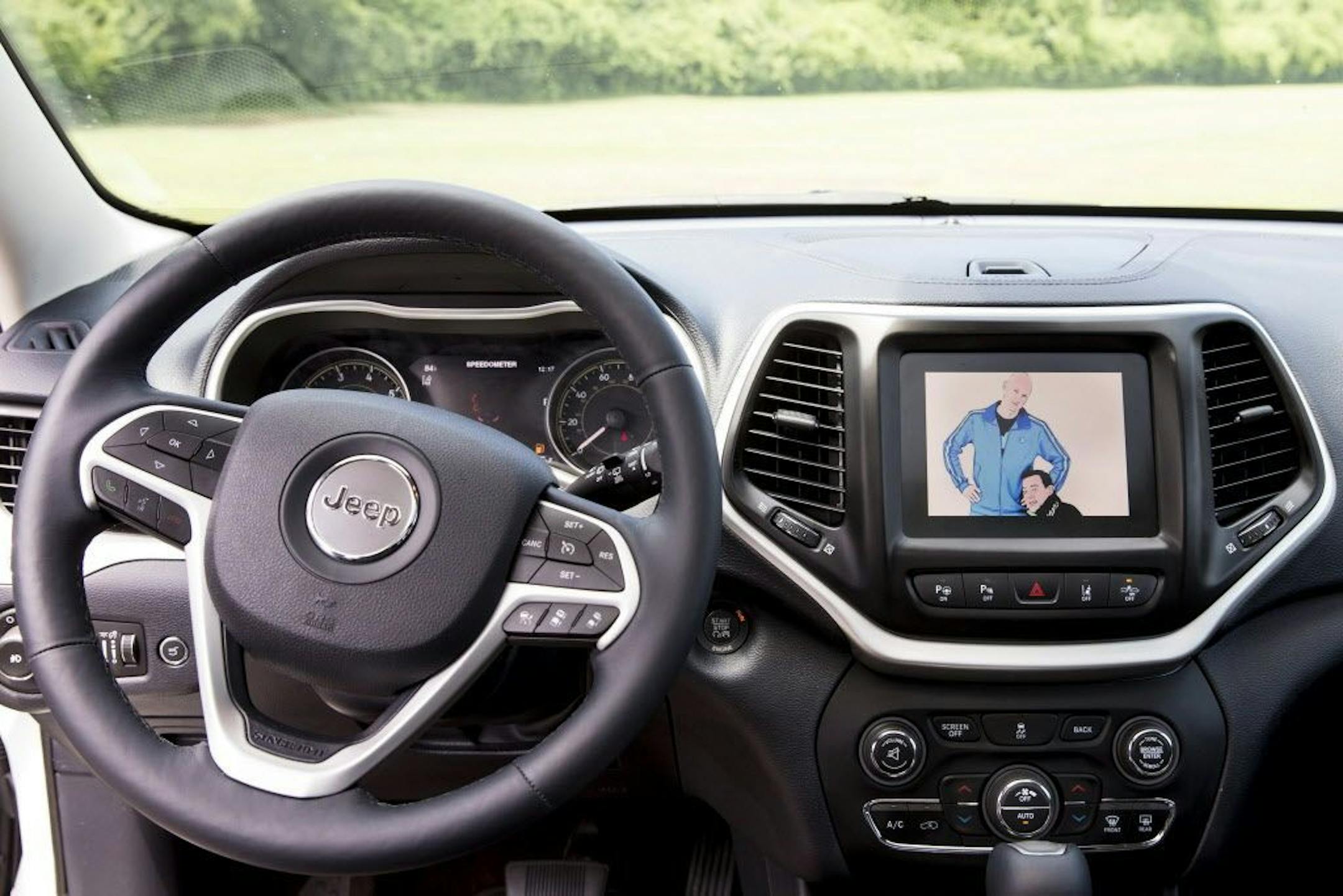 Charlie Miller, left, and Chris Valasek, are displayed on the navigation screen of a Jeep Cherokee, which the duo successfully hacked, in Ladue, Mo., July 23, 2015. The breach showed just how vulnerable the new breeds of web-connected vehicles can be, and the challenges that manufacturers face in defending against attacks common in other technology fields.