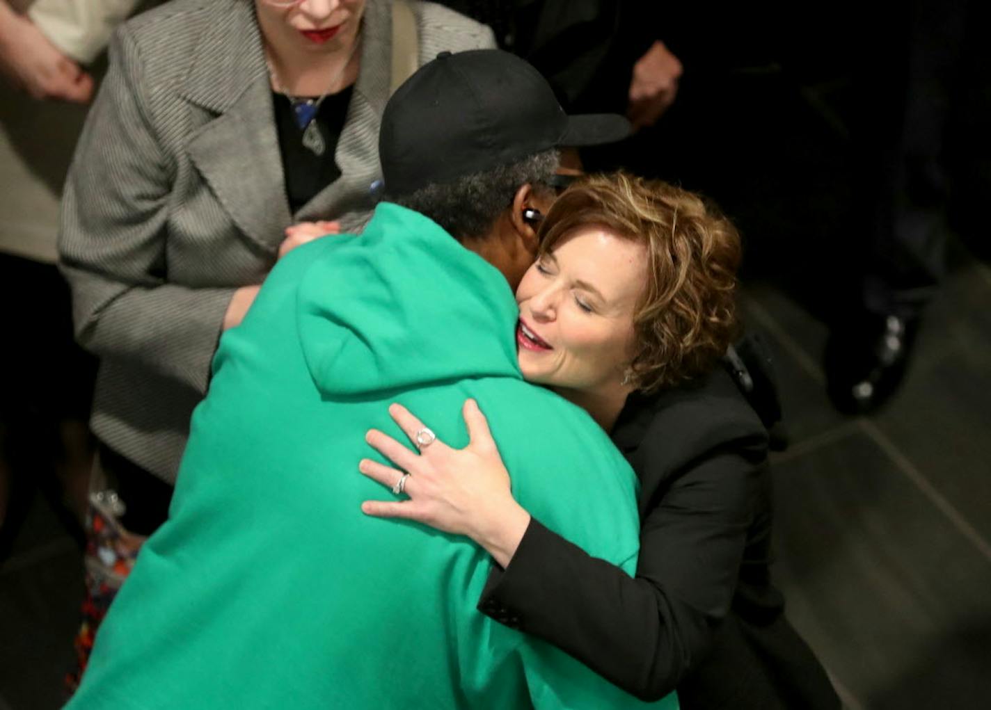 Mayor Betsy Hodges, gets a hug from V.J. Smith of MAD DADs, after the unveiling of a plan for a "safe and inviting Hennepin Avenue," during a press conference at the Mayo Clinic Square Thursday, March 30, 2017.