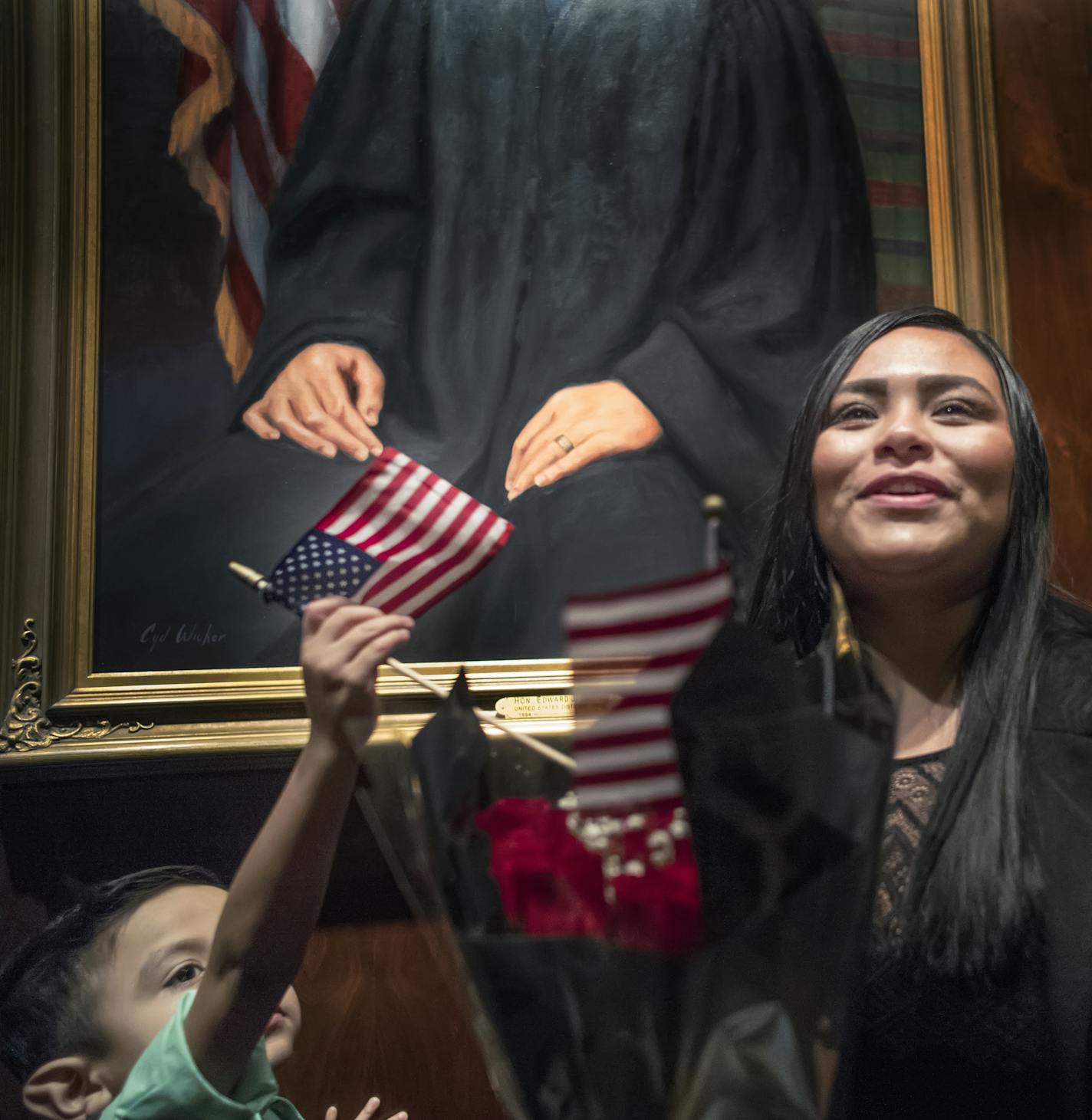 United States born Daniel Valderrama,4, put a flag in the bouquet of his mother, Miriam Duque of Lakeville who became a United States Citizen.They were standing under the portrait of the Honorable Edward J Devitt in the court room where dozens of immigrants became U.S. citizens on Wednesday in St. Paul. Some officials are still trying to sort out the effects of President Trump's executive order banning immigration from seven Muslim-majority countries. ] RICHARD TSONG-TAATARII &#x2022; richard.ts