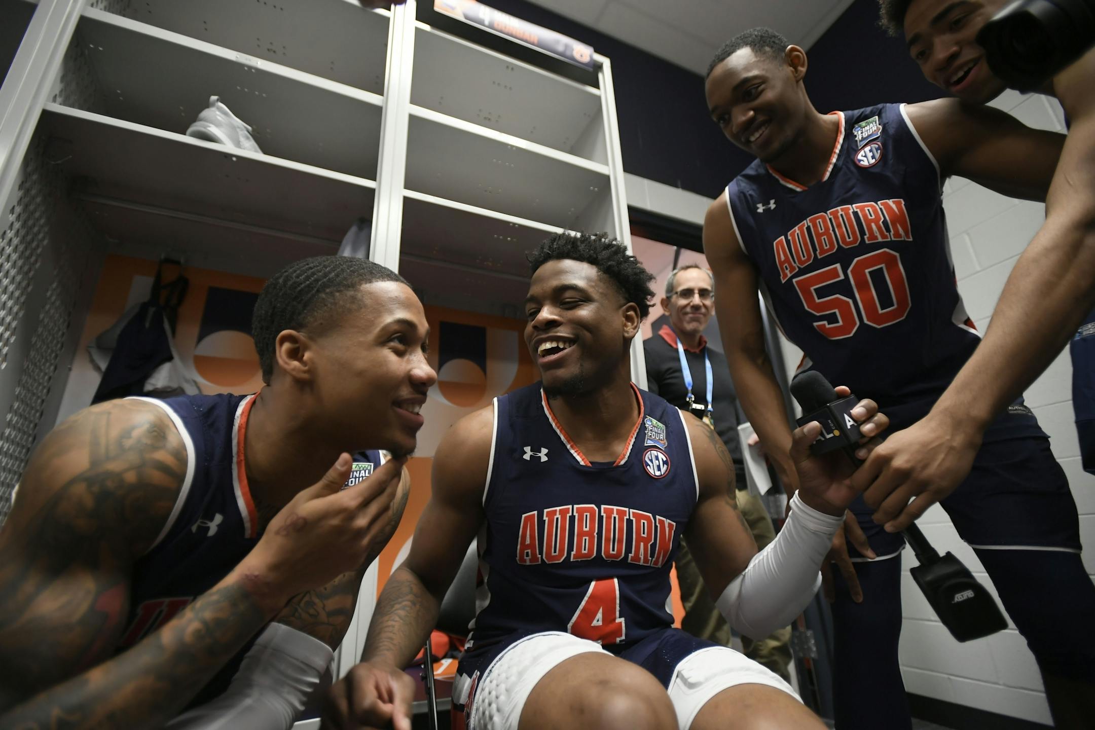 Auburn guard J'Von McCormick (12) jokes with teammates Auburn guard Malik Dunbar (4), Auburn center Austin Wiley (50) and Auburn forward Myles Parker, right, during media availability in the team locker room.
