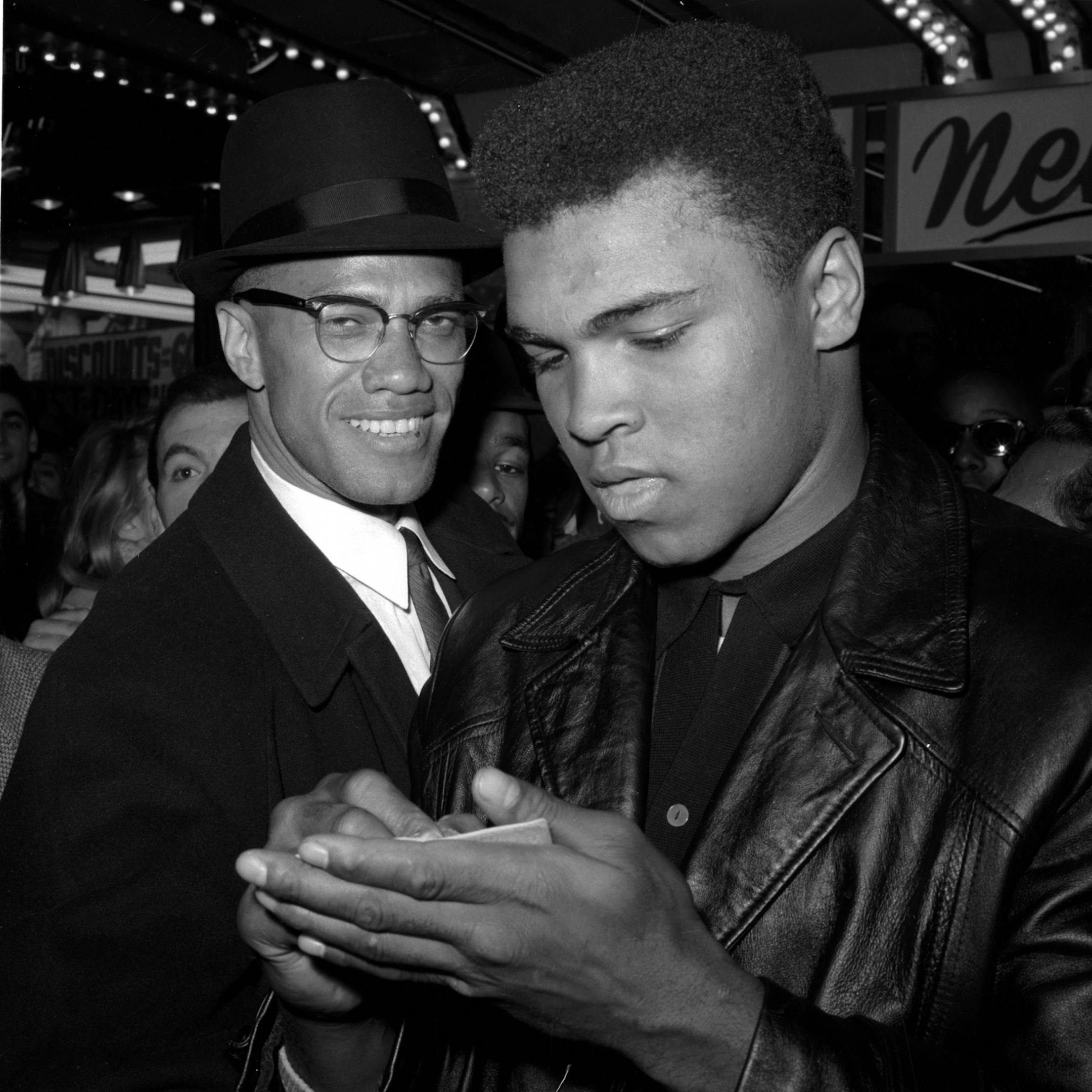 World Heavyweight Boxing Champion, Muhammad Ali, right, is shown with Black Muslim Leader, Malcolm X, outside the Trans-Lux Newsreel Theater on Broadway at 49th Street, New York City, March 1, 1964. They had just watched a screening of films on Ali's title fight with Sonny Liston in Miami Beach, Feb. 25. (AP Photo) ORG XMIT: APHS025731