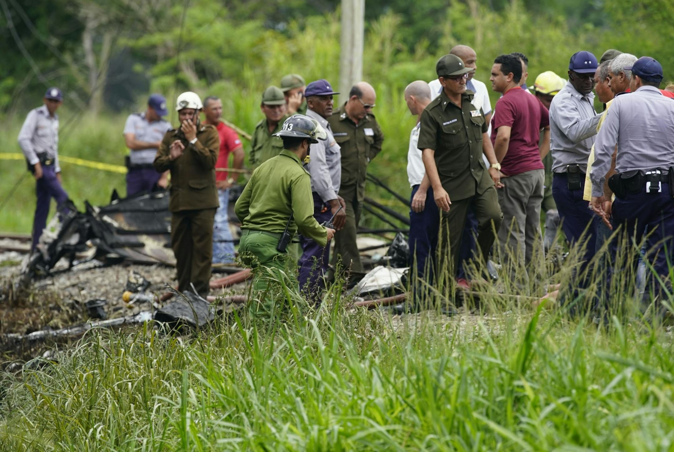 Rescue and search workers on the site where a Cuban airliner with more than 100 passengers on board plummeted into a yuca field just after takeoff from the international airport in Havana, Cuba, Friday, May 18, 2018.