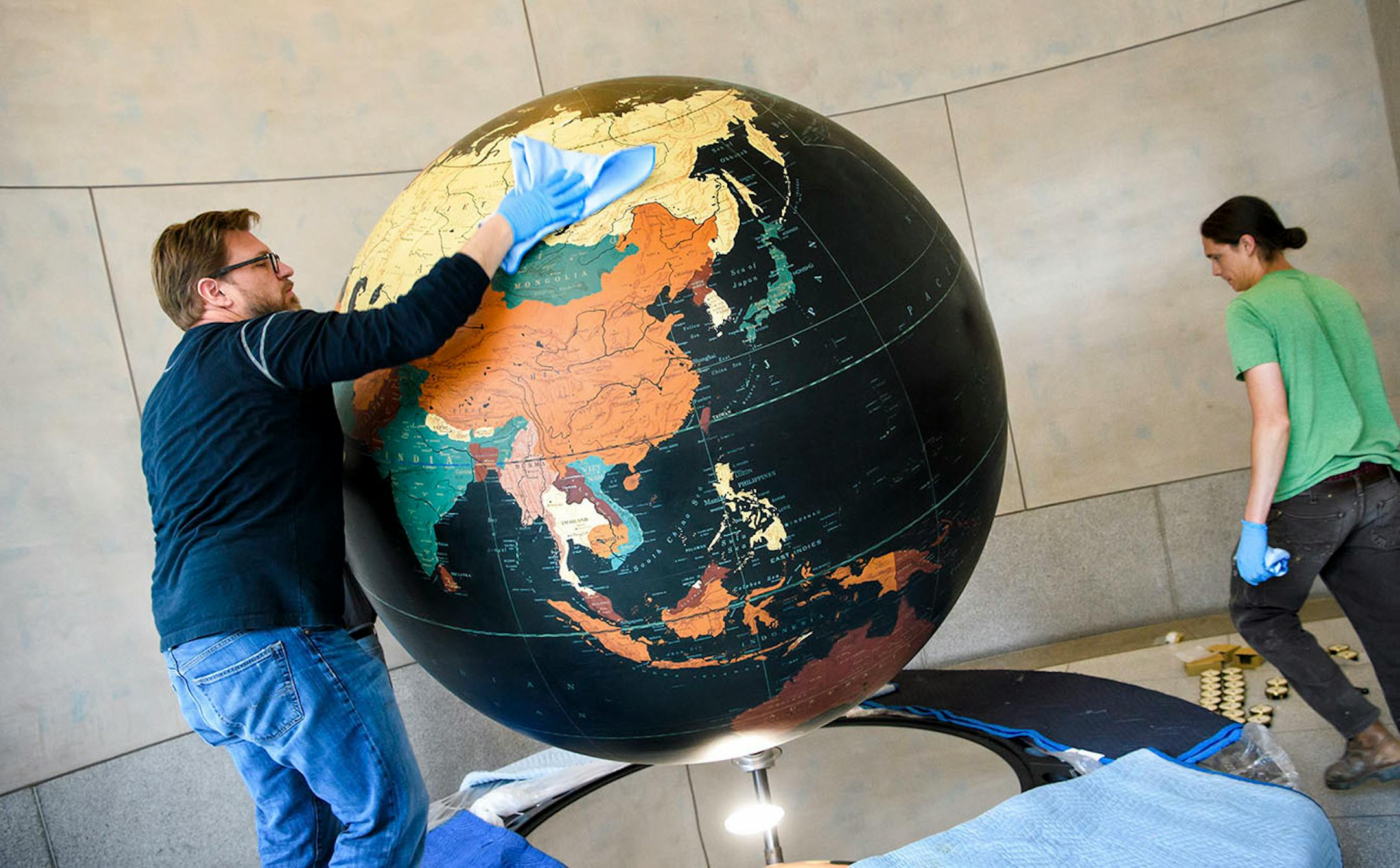Tim Quady owner of Blue Rhino Studio in Eagan gave the globe a final wipe down.