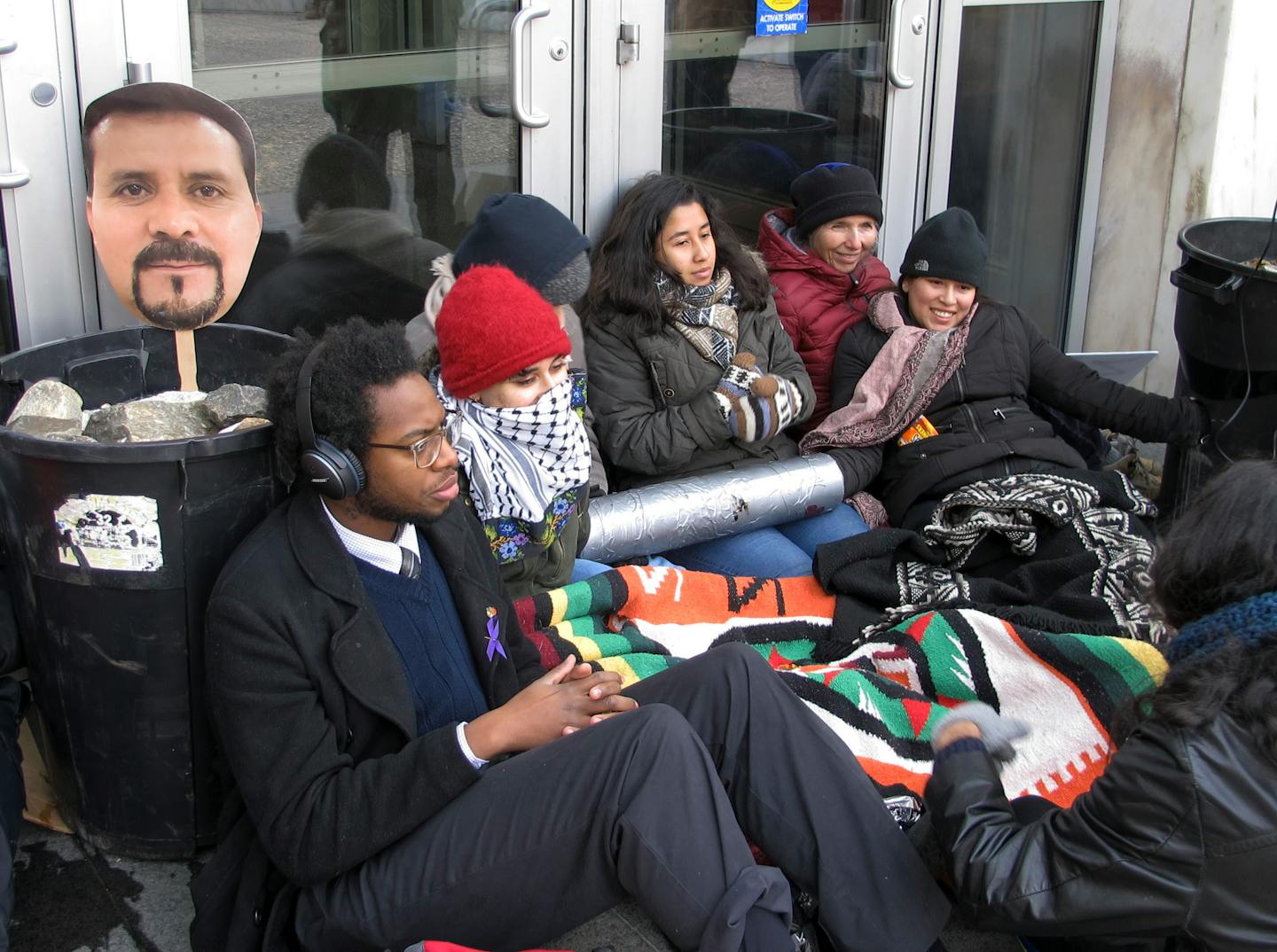 In this Nov. 30, 2018 file photo, supporters of Nelson Pinos, an immigrant from Ecuador who has been living in a church for a year to avoid deportation, block the front doors outside the federal building, in Hartford, Conn. An attorney for Pinos, who was arrested in Minneapolis and ordered deported from the U.S. 25 years ago, goes to court Tuesday to ask that his case be reopened.