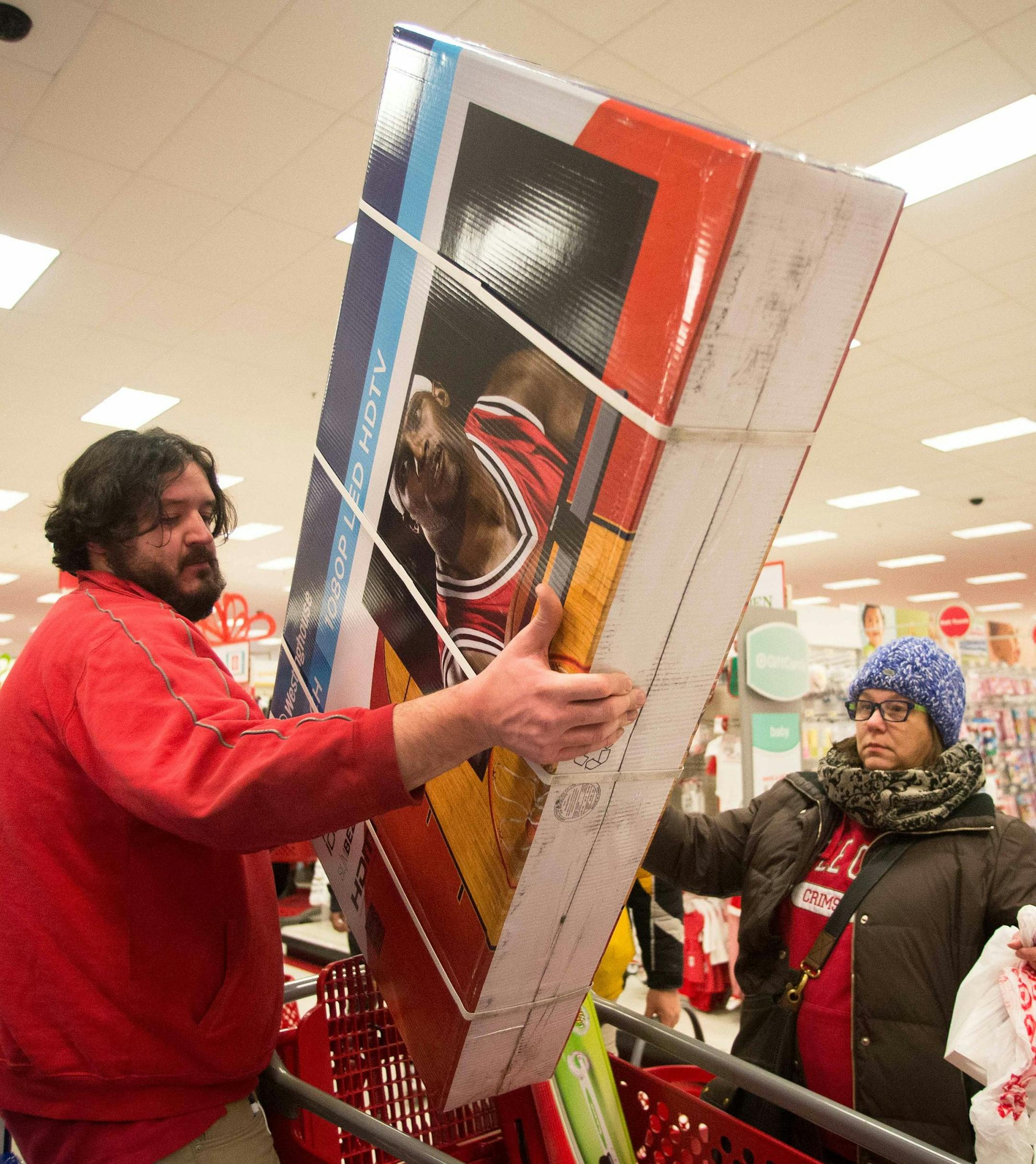 Super Target employee Jeremy Streit helps lift a big screen television into the cart of Tonii Simmons during Thanksgiving night shopping. ] AARON LAVINSKY • aaron.lavinsky@startribune.com Black Friday got an earlier kick off this year on Thanksgiving Day. Shoppers lined up early to be the first to get big deals on their holiday shopping at Target in Roseville Thursday, Nov. 27, 2014. ORG XMIT: MIN1411271928050009