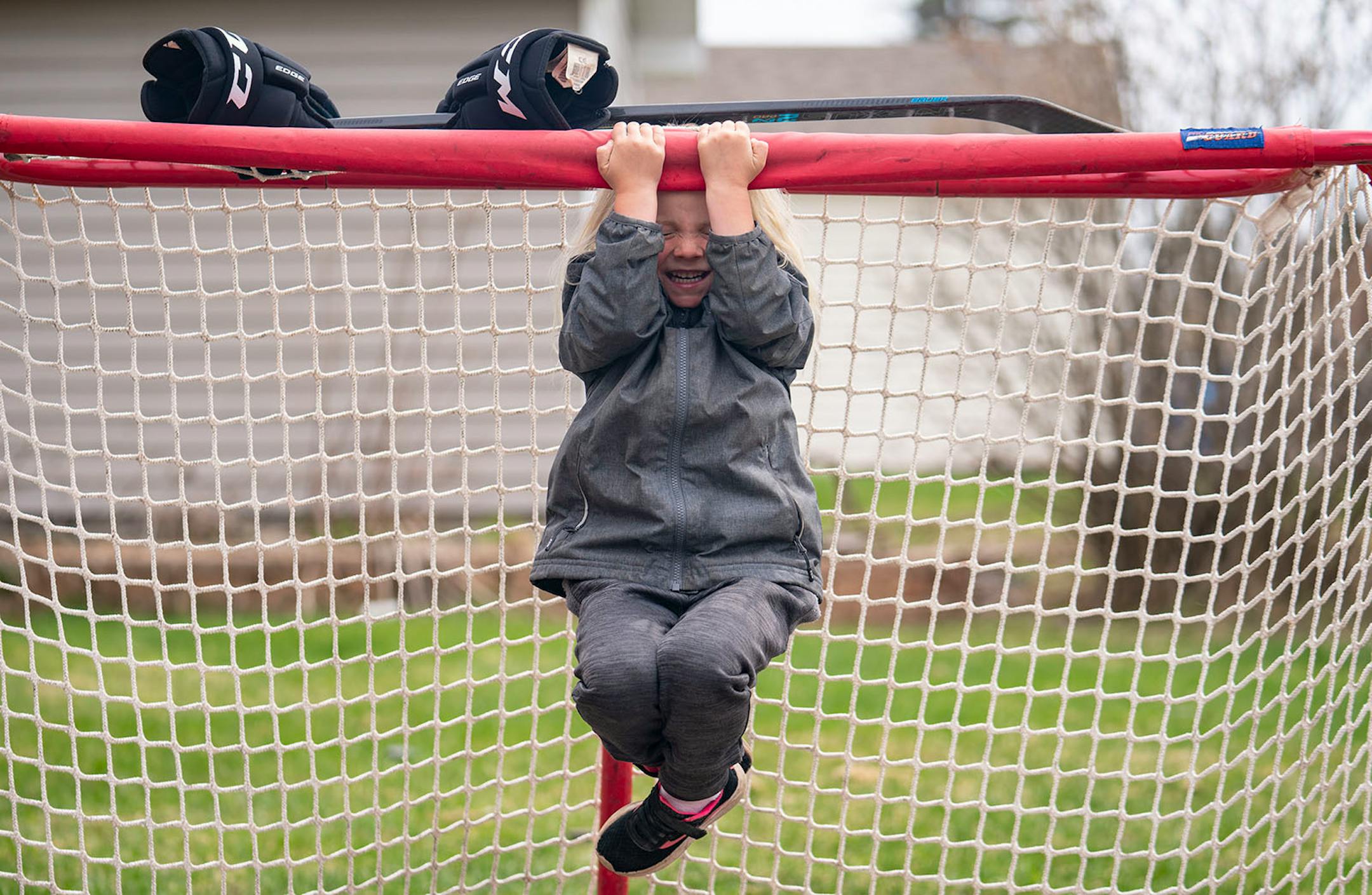 Anna Fahlin (4) showed off her pull up skills inside of her family's hockey net in Cloquet. Anna said that the virus makes her angry because "we can't play with out friends". But she finds happiness just shooting pucks, riding her bike or digging for worms in the backyard.