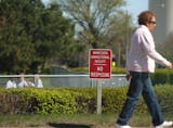 A woman walked past the Minnesota correctional facility for women in Shakopee, Minn. on April 3, 2012. Instead of a fenced property the women's prison has a hedge and short fence. At that point in the day a group of women were playing softball on the prison property. (RENEE JONES SCHNEIDER * reneejones@startribune.com)
