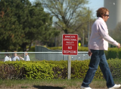 A woman walked past the Minnesota correctional facility for women in Shakopee, Minn. on April 3, 2012. Instead of a fenced property the women's prison has a hedge and short fence. At that point in the day a group of women were playing softball on the prison property. (RENEE JONES SCHNEIDER * reneejones@startribune.com)