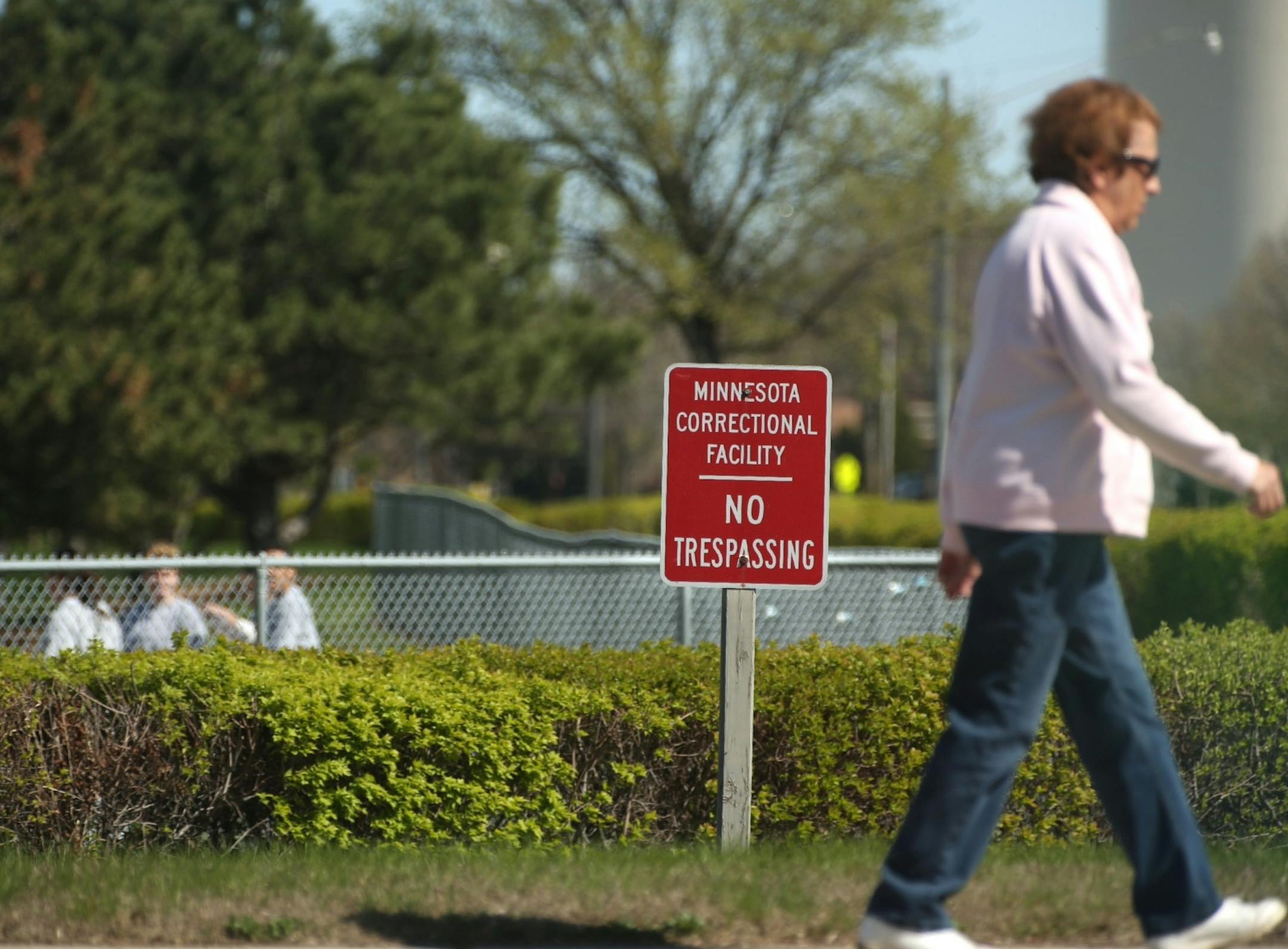 A woman walked past the Minnesota correctional facility for women in Shakopee, Minn. on April 3, 2012. Instead of a fenced property the women's prison has a hedge and short fence. At that point in the day a group of women were playing softball on the prison property. (RENEE JONES SCHNEIDER * reneejones@startribune.com)