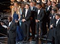 Director Steve McQueen, left, speaks while he and the cast and crew of "12 Years a Slave" accept the award for best picture during the Oscars at the D