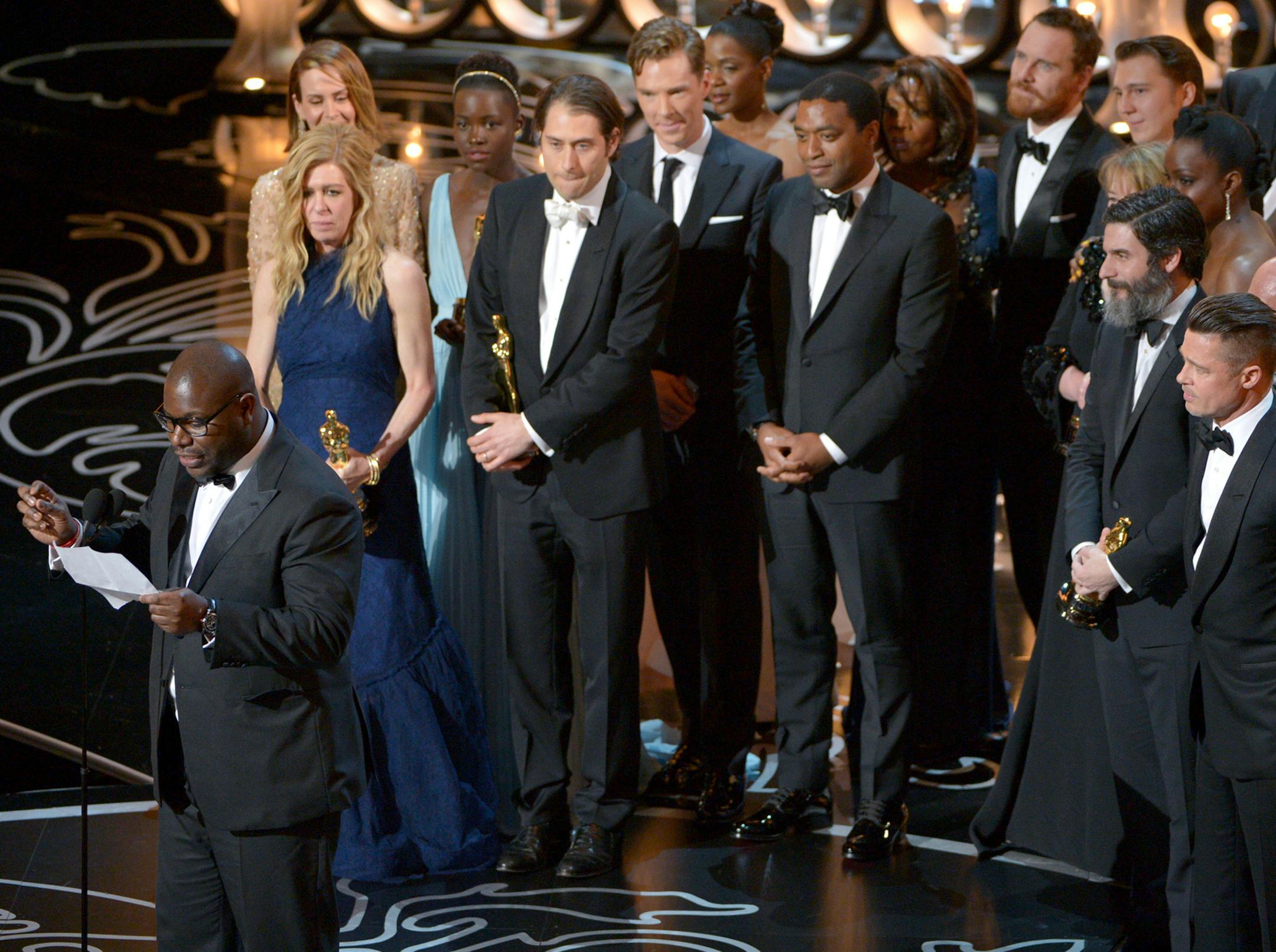 Director Steve McQueen, left, speaks while he and the cast and crew of "12 Years a Slave" accept the award for best picture during the Oscars at the Dolby Theatre on Sunday, March 2, 2014, in Los Angeles. (Photo by John Shearer/Invision/AP) ORG XMIT: CACJ568