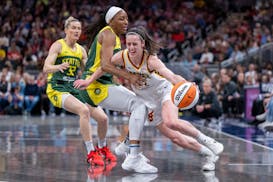 Indiana Fever guard Caitlin Clark, right, drives against Seattle Storm forward Nneka Ogwumike on May 30 in Indianapolis.
