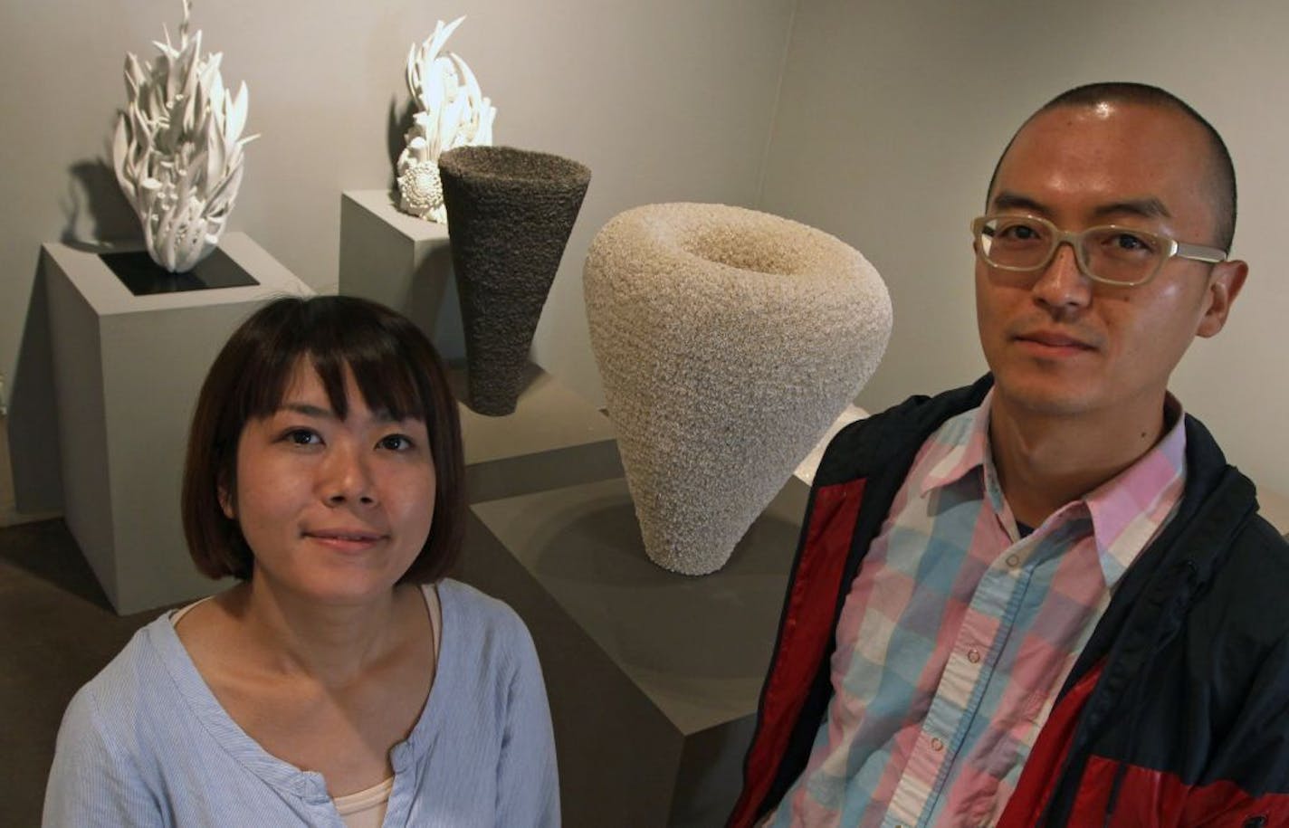 Japanese artists Rina Hongo and Naoto Nakada with some of the artwork of the "New Millenium" show at the Northern Clay Center.