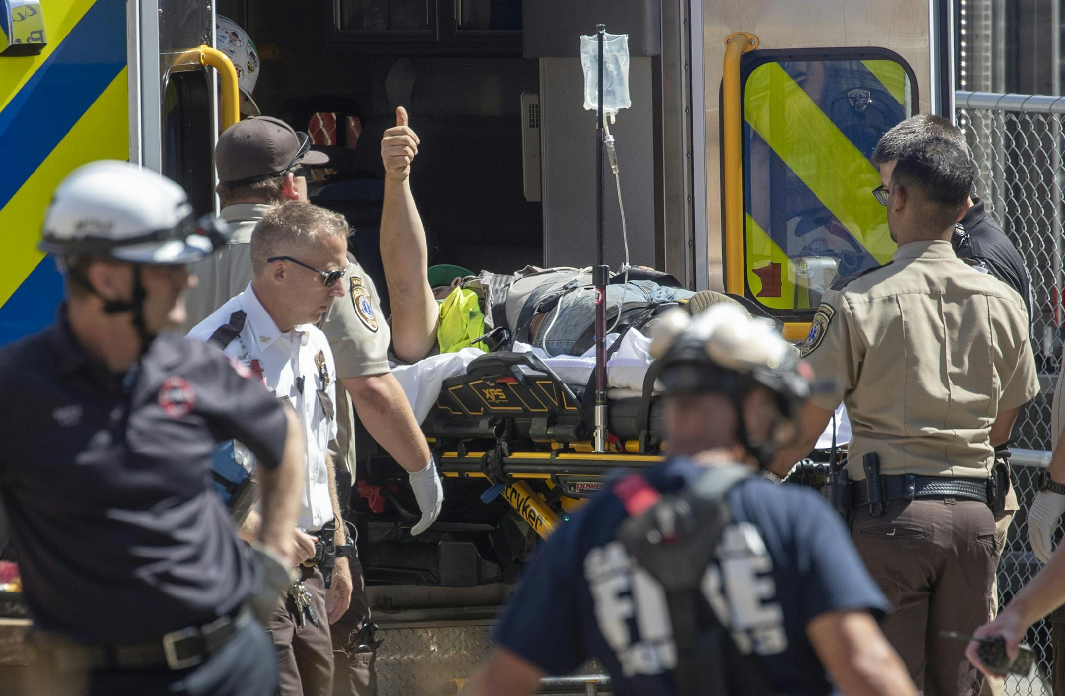 A construction worker gives a thumbs-up gesture after firefighters freed him after he was trapped when a trench collapsed at a construction site July 29 in Minneapolis.