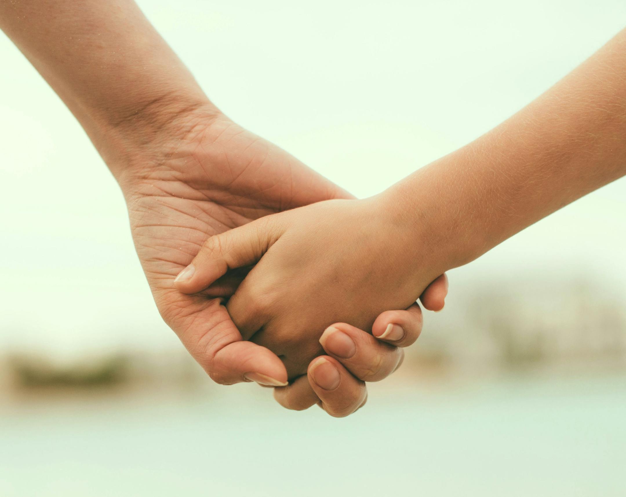 Mother holding hand of her daughter. istock